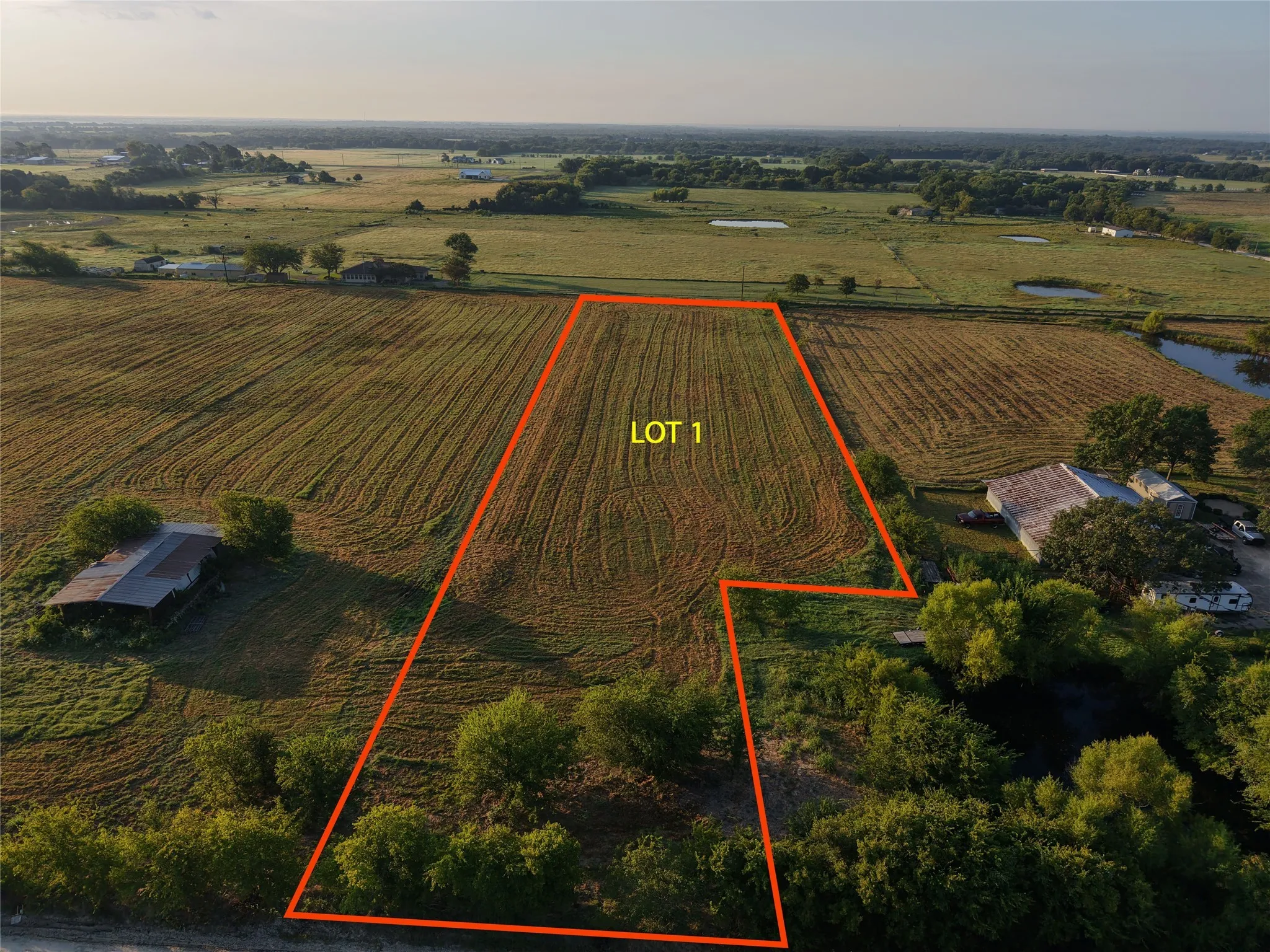 Overview of rural landscape with property parcel outlined and large plots for crops