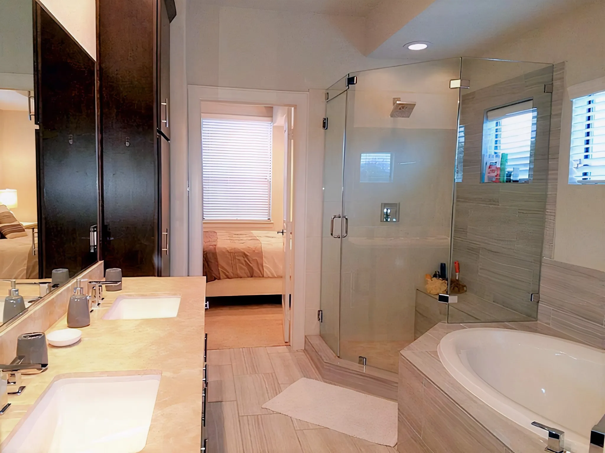 The master bathroom boasts two sinks for added convenience, a frameless glass shower, a large tub and a walk-in closet with natural light.