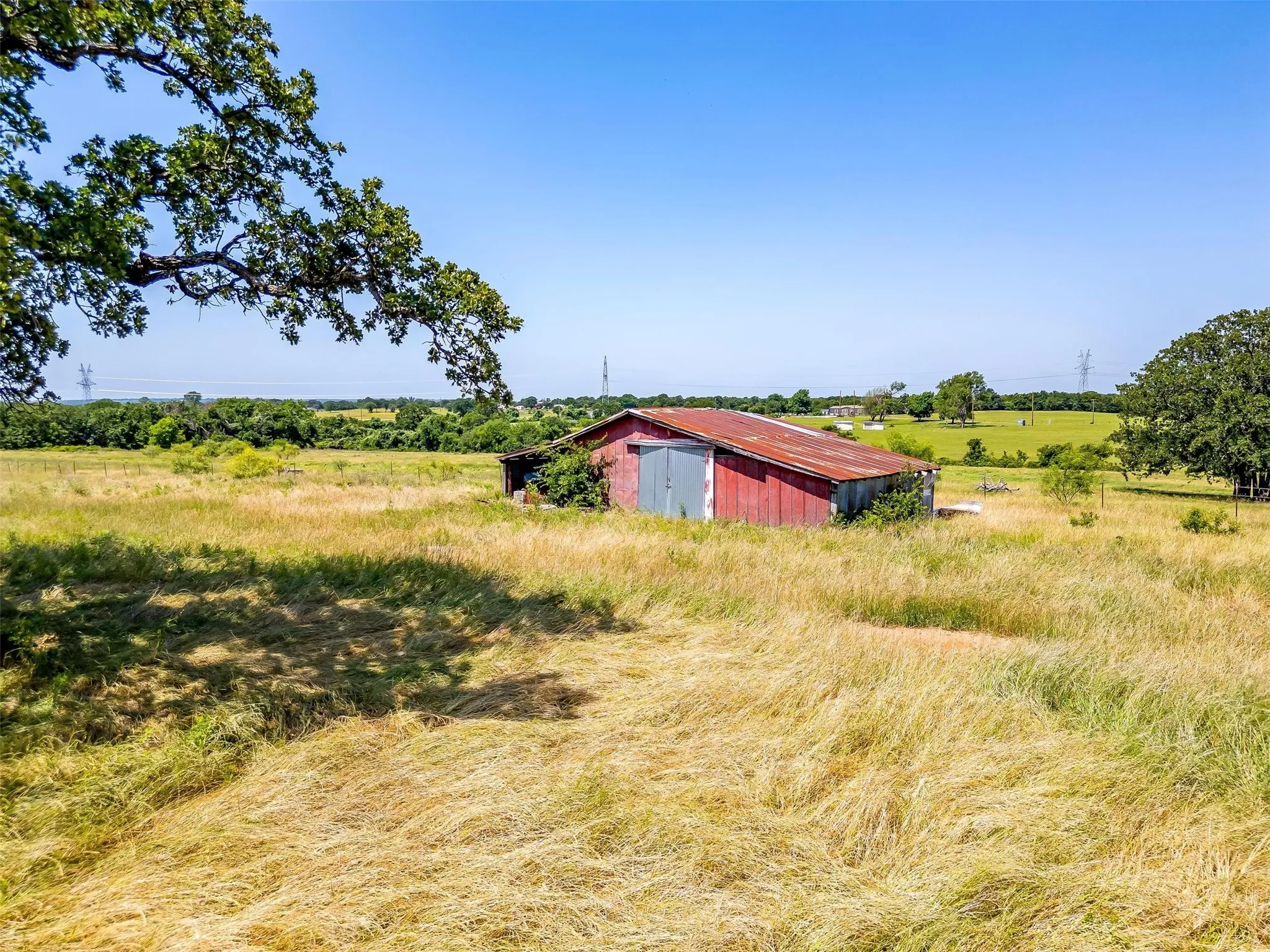 View of yard with a pole building, a rural view, and an outbuilding