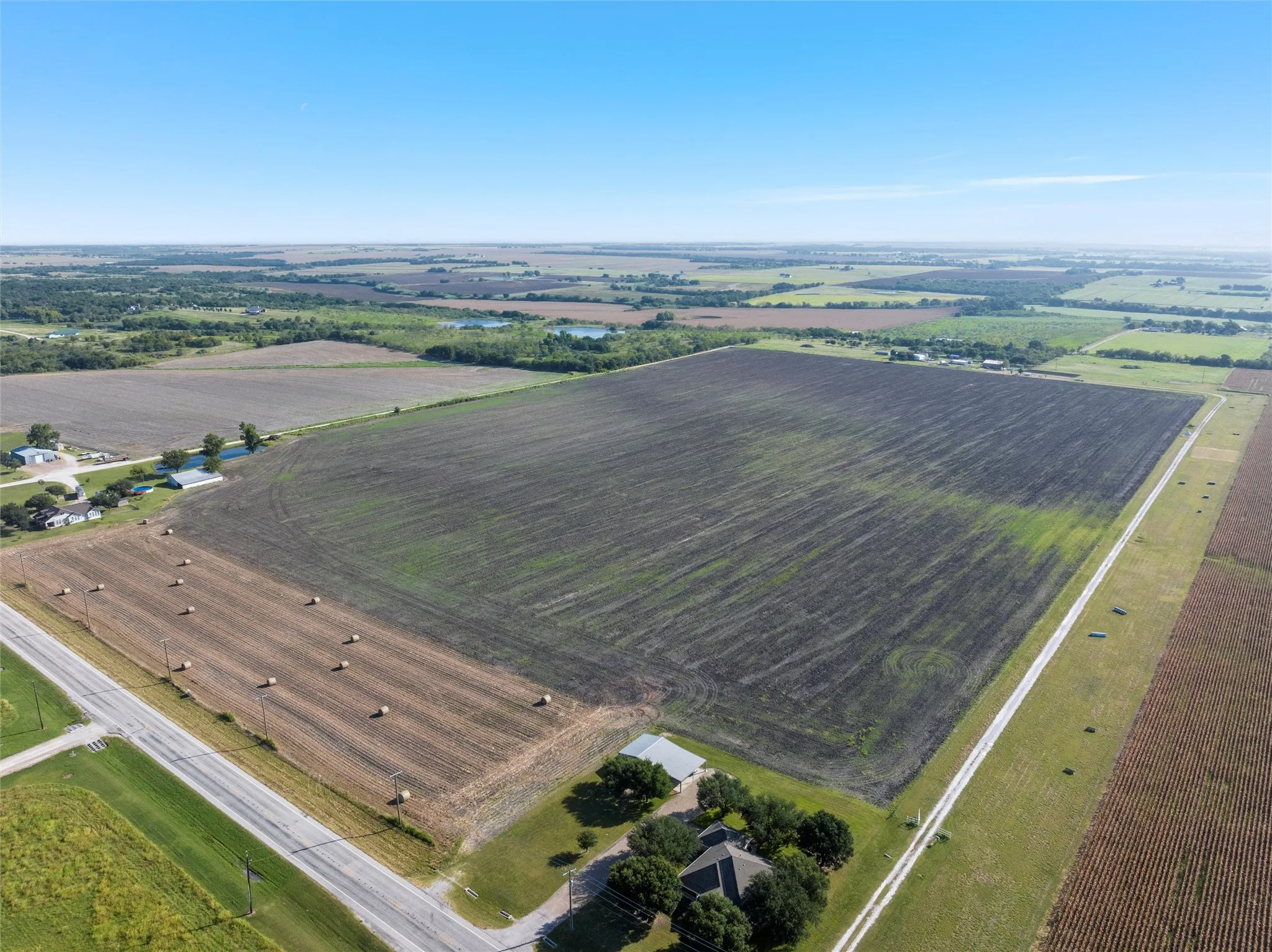 Aerial view of property and surrounding area with rural landscape and rows of crops