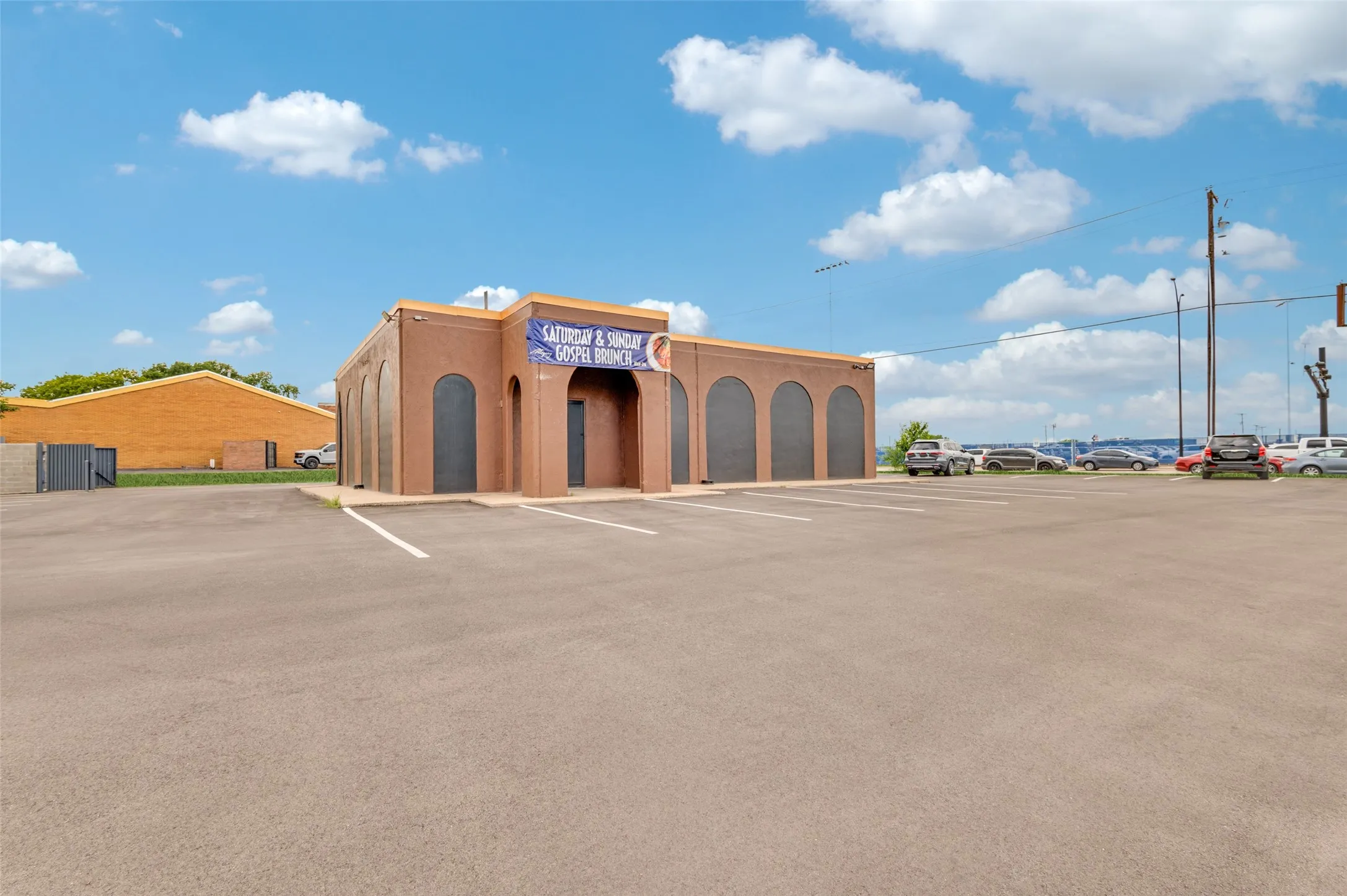 View of building exterior featuring uncovered parking