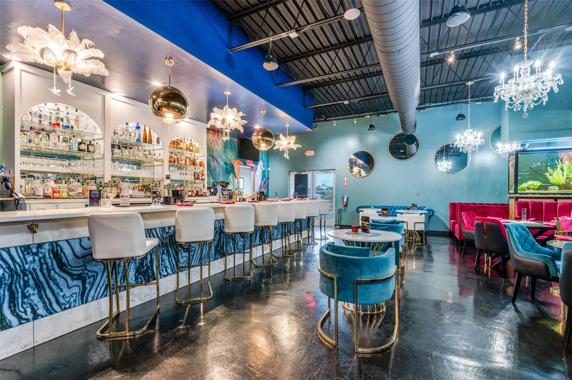 Community bar area featuring concrete flooring, a chandelier, and a towering ceiling
