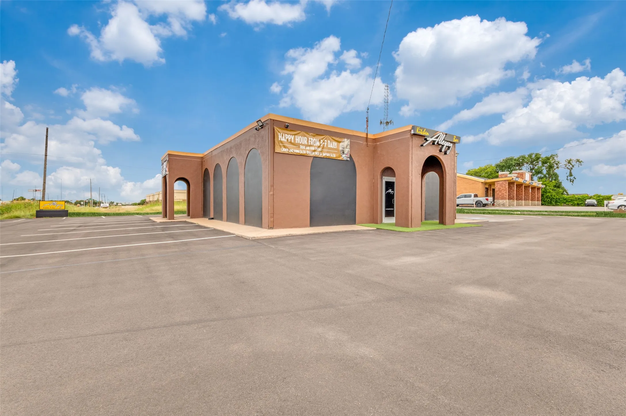 View of building exterior featuring uncovered parking