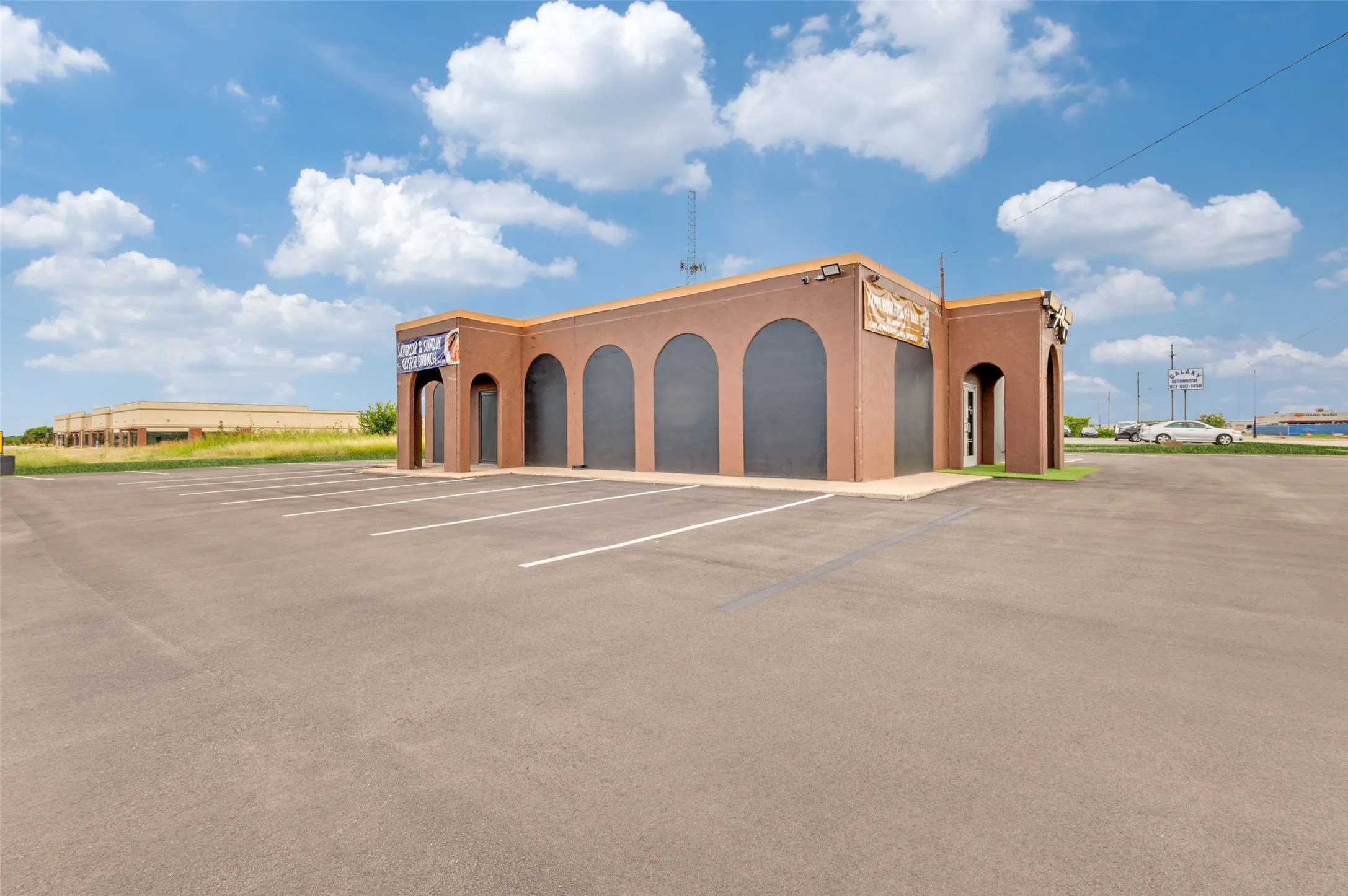 View of building exterior featuring uncovered parking