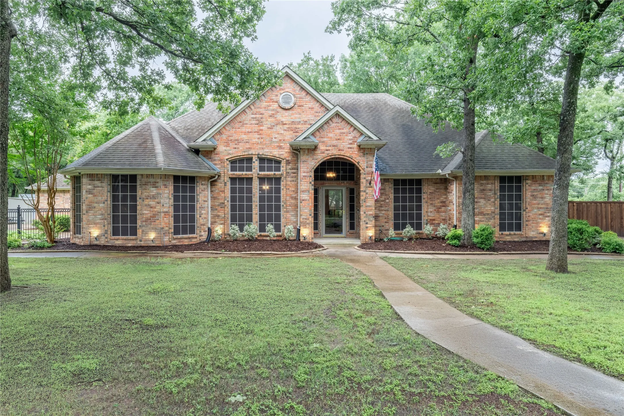 View of front of property with roof with shingles and brick siding