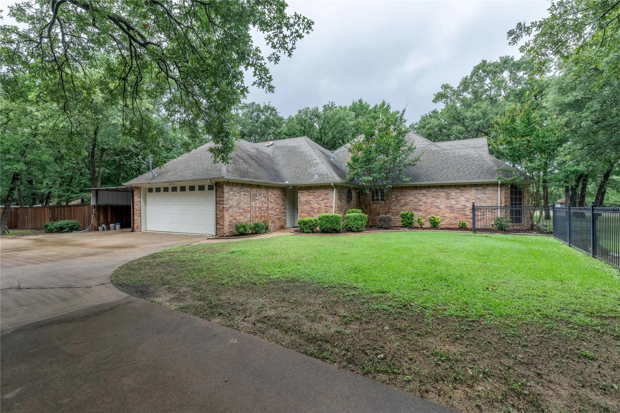 Ranch-style house featuring driveway, an attached garage, brick siding, and a shingled roof