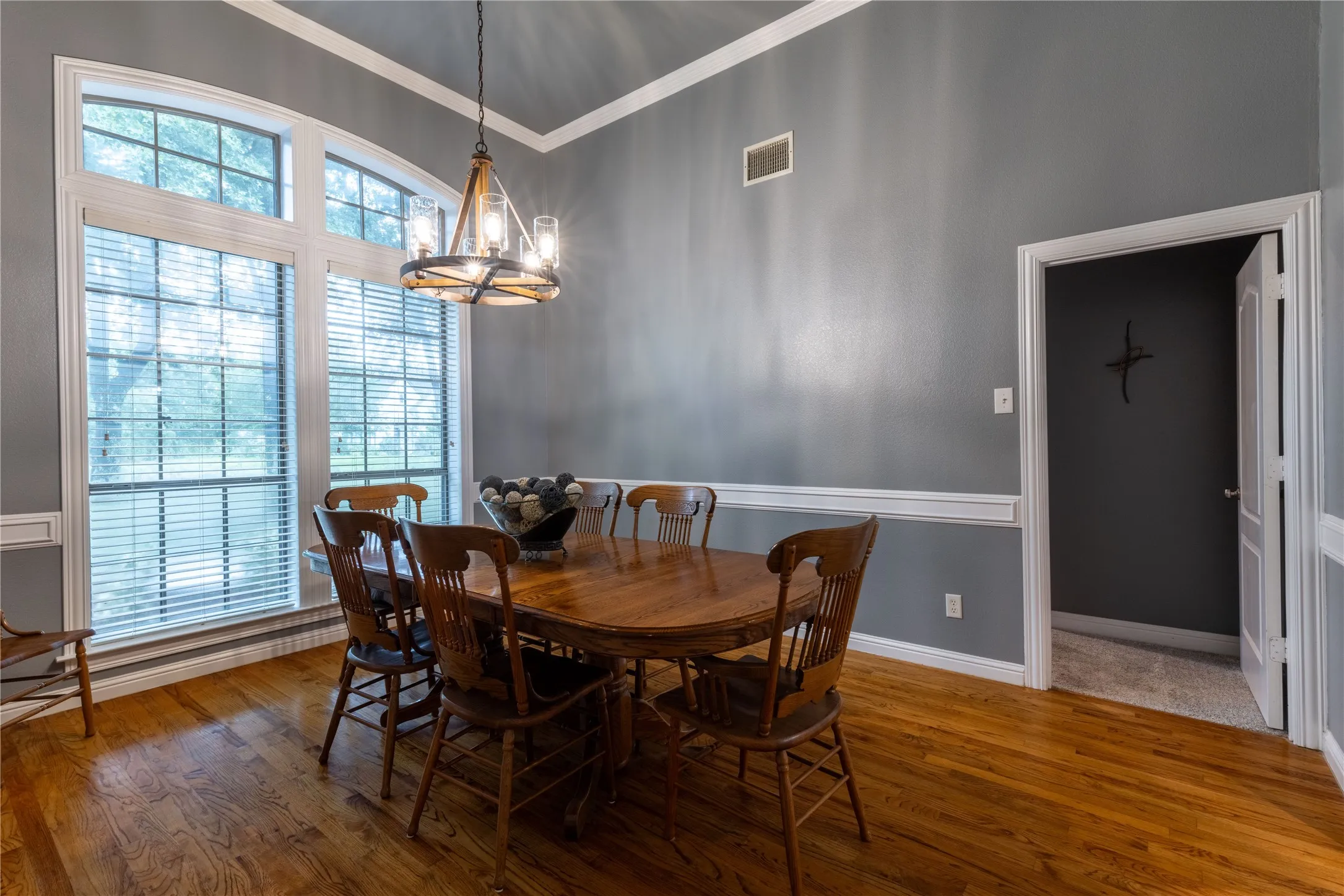 Dining room with a chandelier, crown molding, and wood finished floors