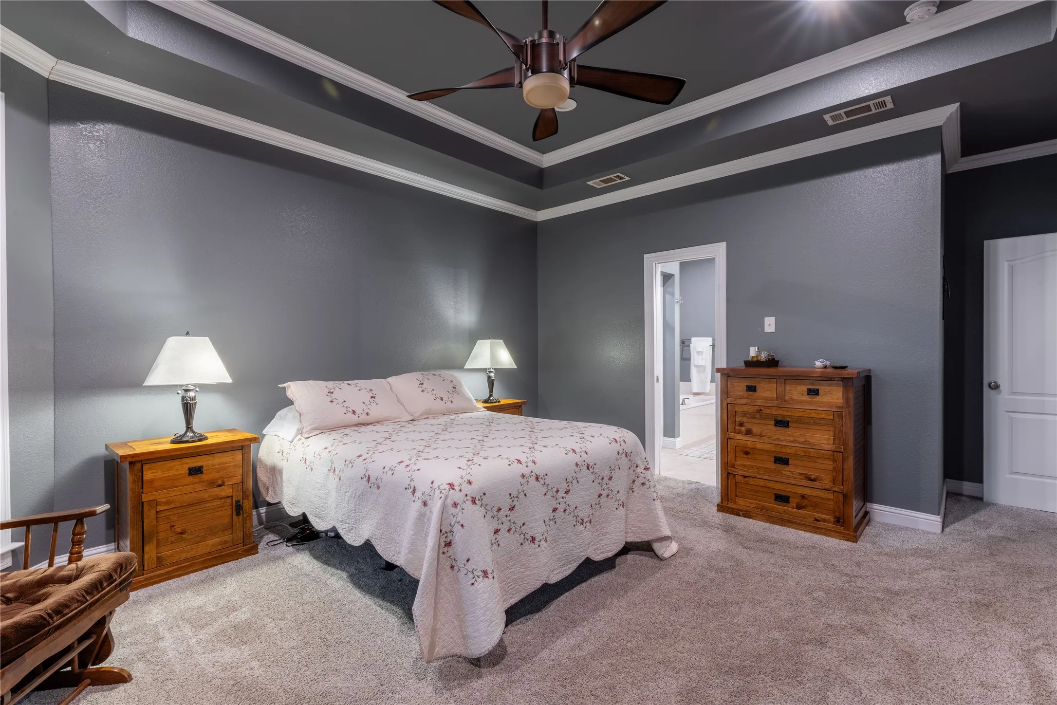 Bedroom featuring carpet, crown molding, a raised ceiling, and ceiling fan