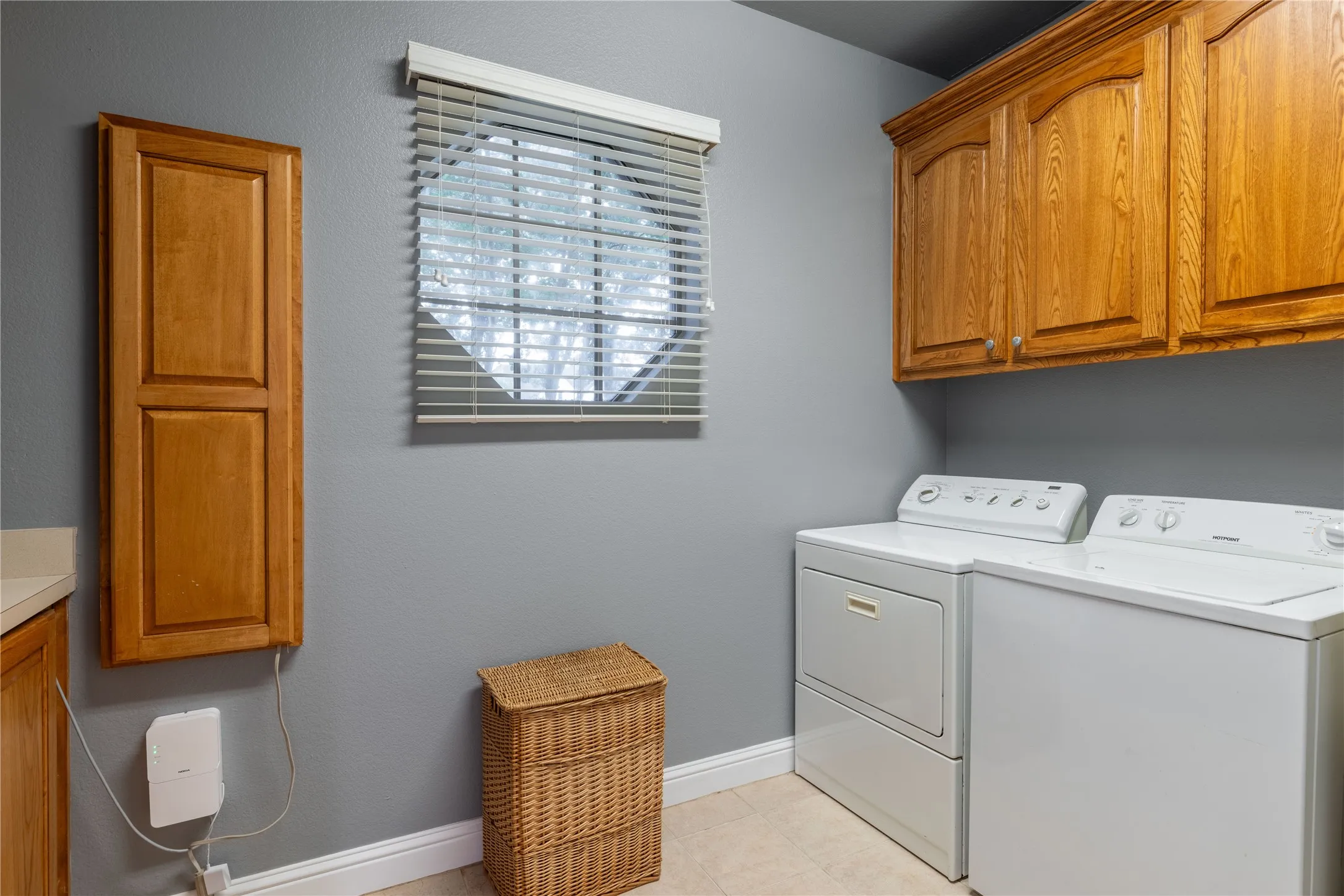 Laundry area featuring cabinet space, independent washer and dryer, sink and tile flooring