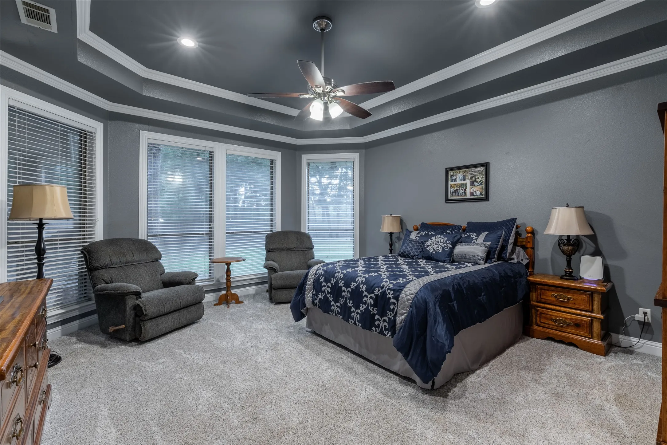Bedroom with carpet, a tray ceiling, ornamental molding, recessed lighting, and ceiling fan