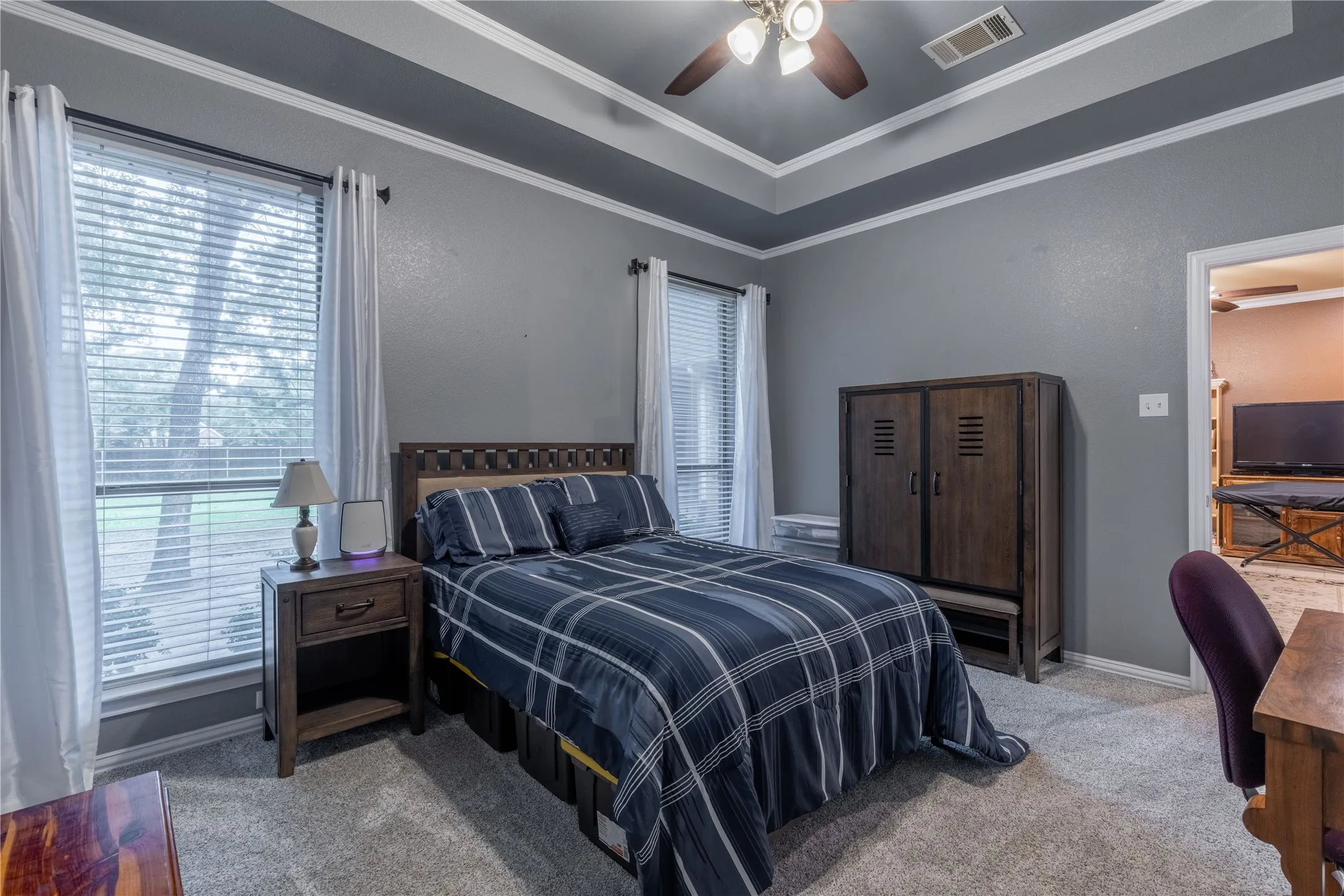 Bedroom with carpeted floors, crown molding, and ceiling fan