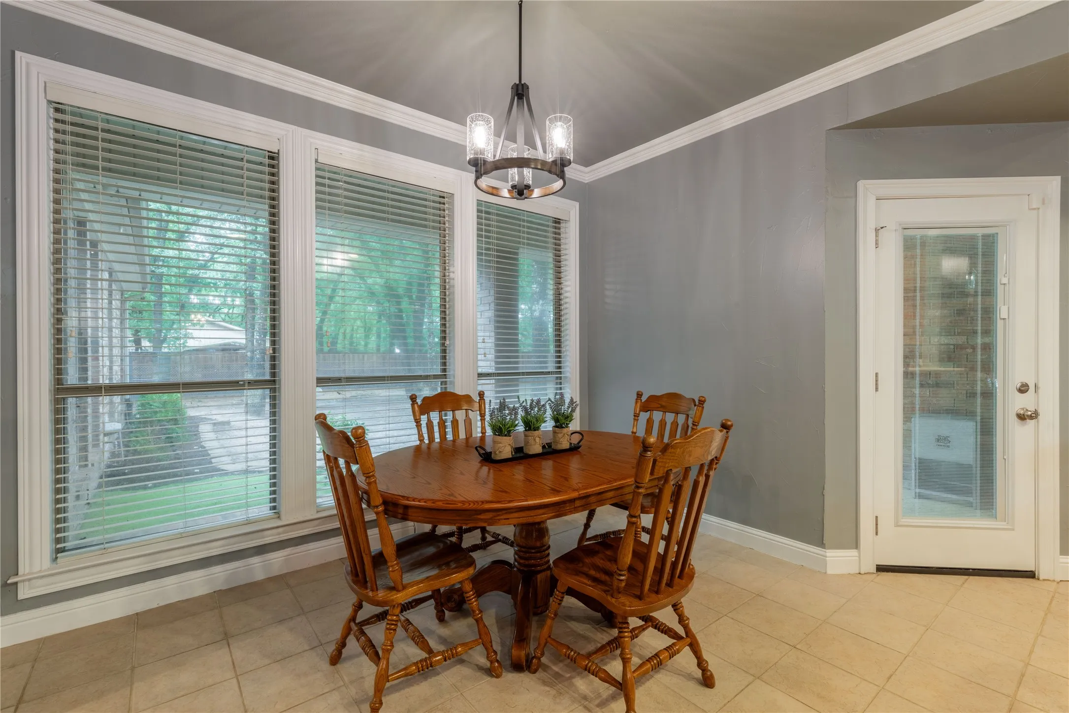Dining room featuring a chandelier, ornamental molding, and light tile patterned flooring