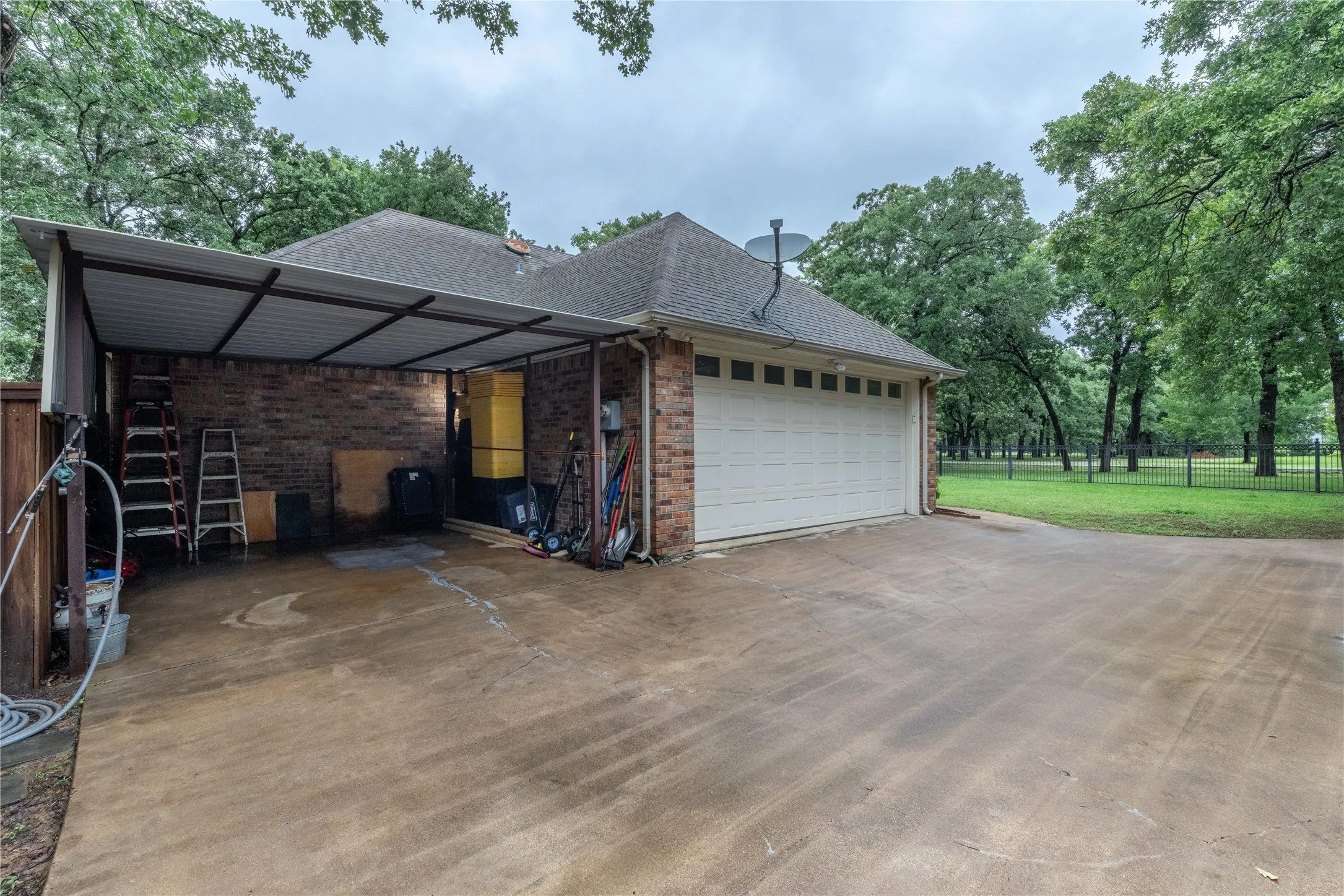 View of property exterior with concrete driveway, an attached garage, brick siding, and a shingled roof