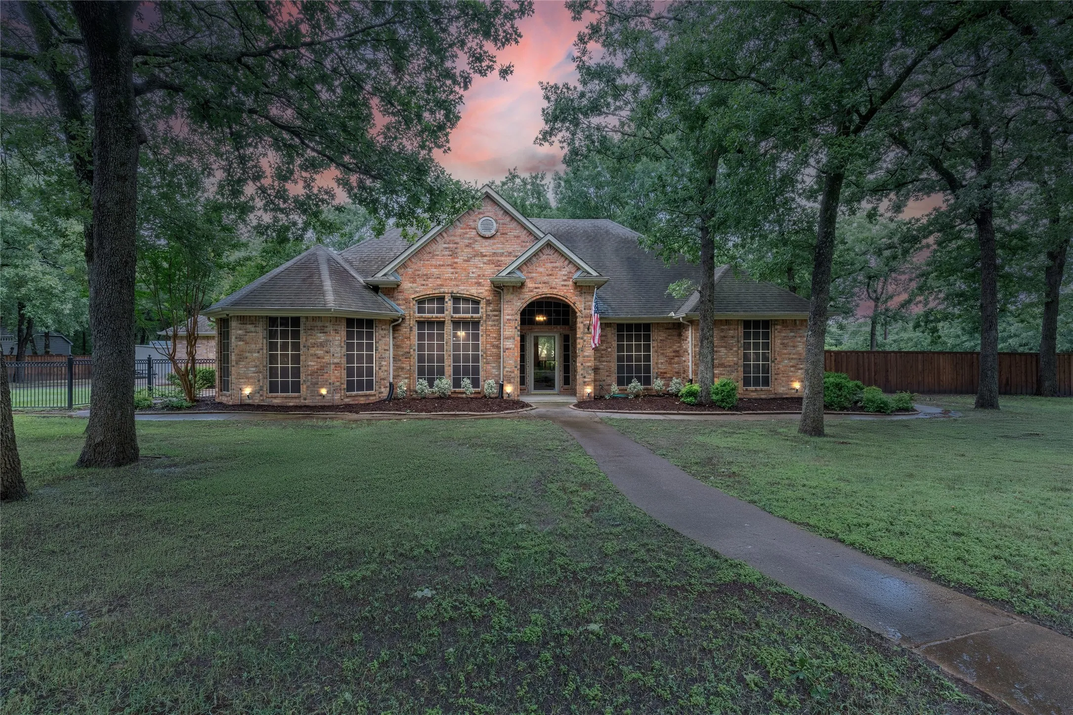 View of front facade with a shingled roof and brick siding
