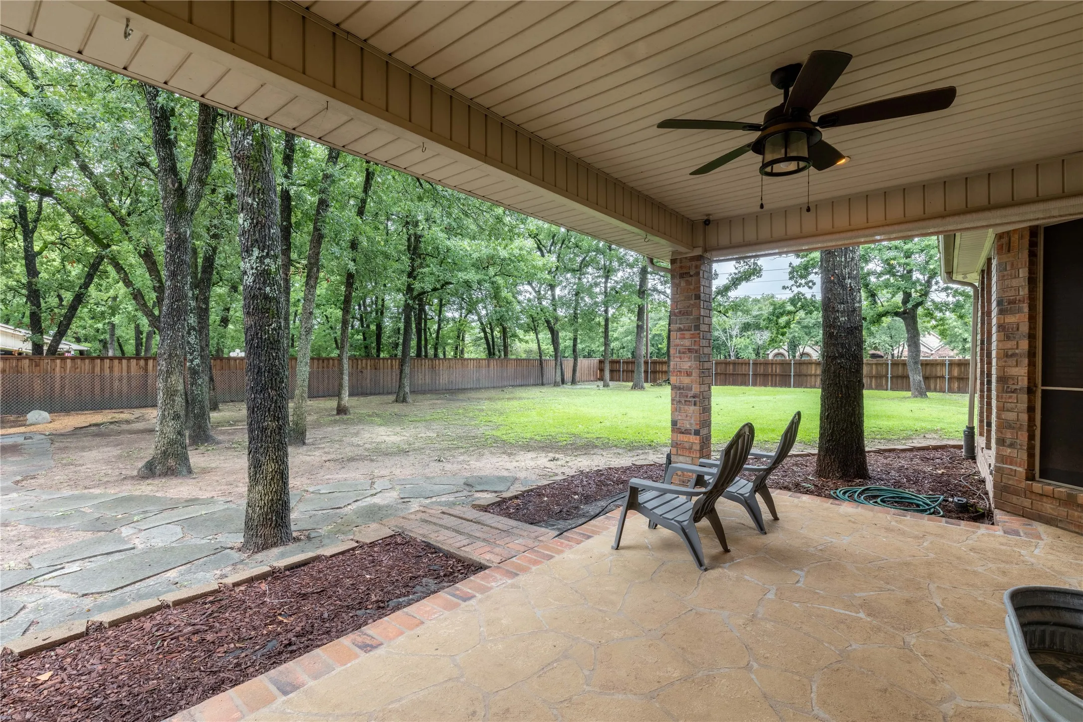 Fenced backyard featuring a patio area and a ceiling fan