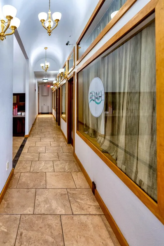Hall with a chandelier and stone tile flooring