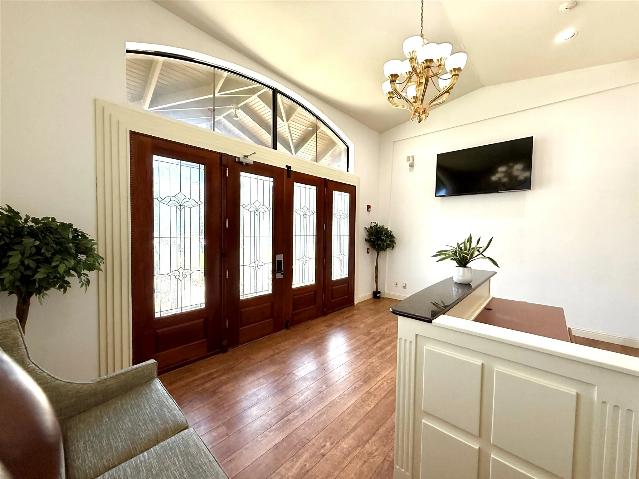 Entryway featuring lofted ceiling, a chandelier, and light wood-type flooring