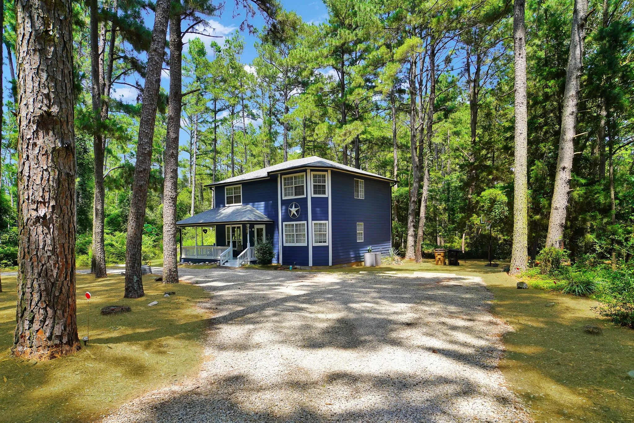 View of front of property featuring a porch and gravel driveway