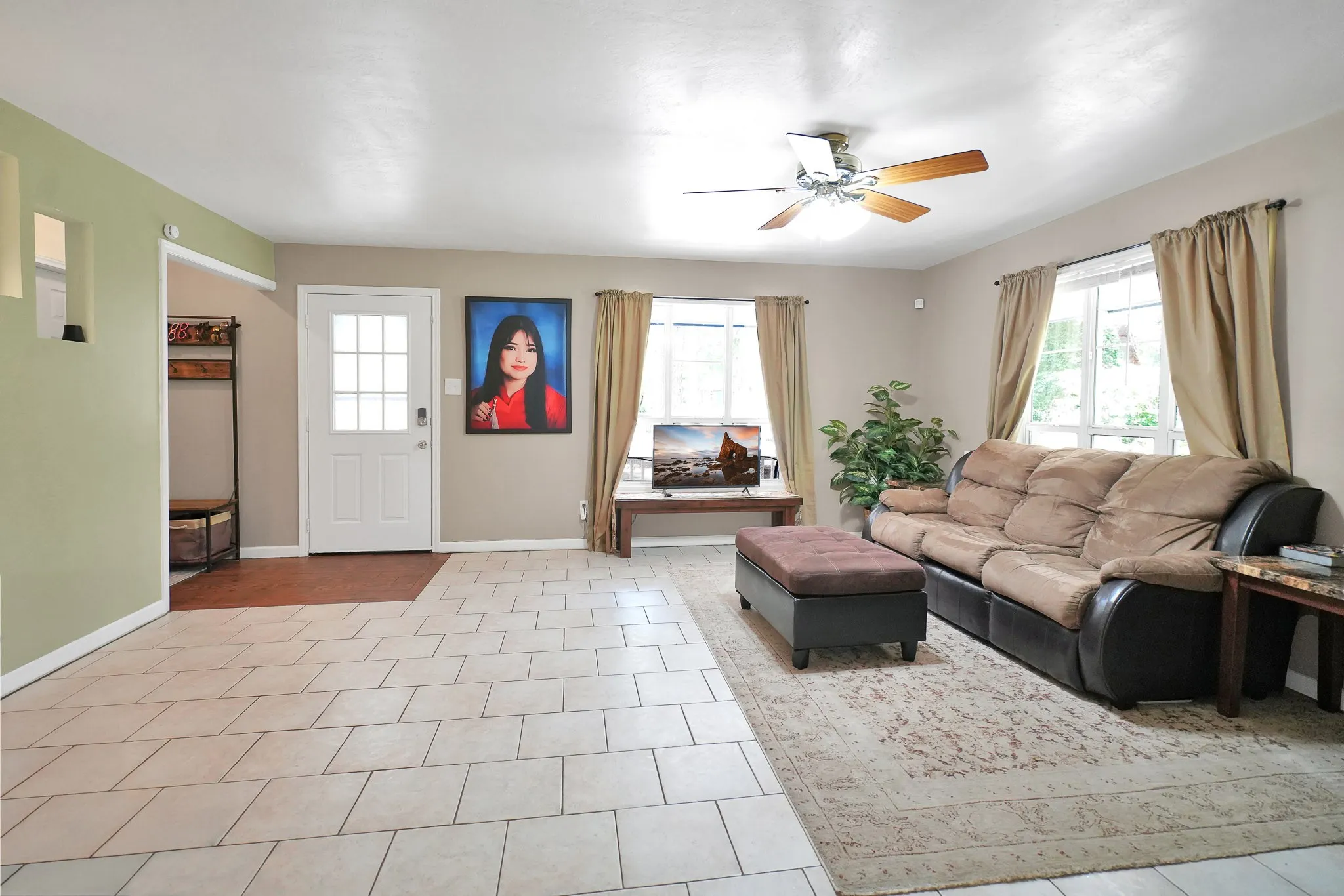 Living area featuring ceiling fan and tile patterned floors