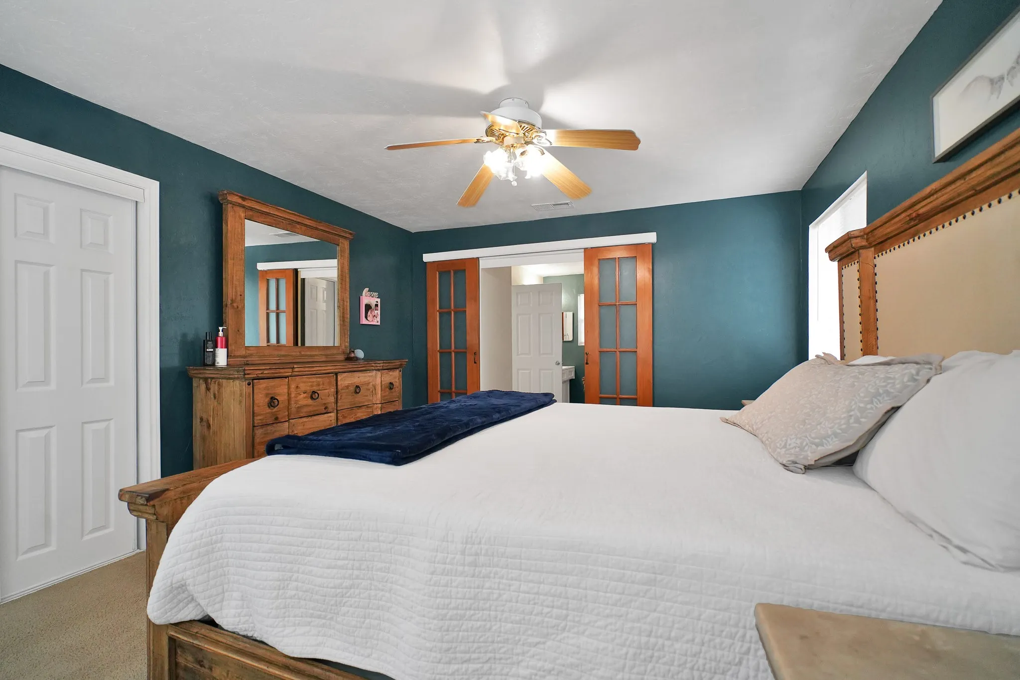 Bedroom with carpet flooring, ceiling fan, and a closet