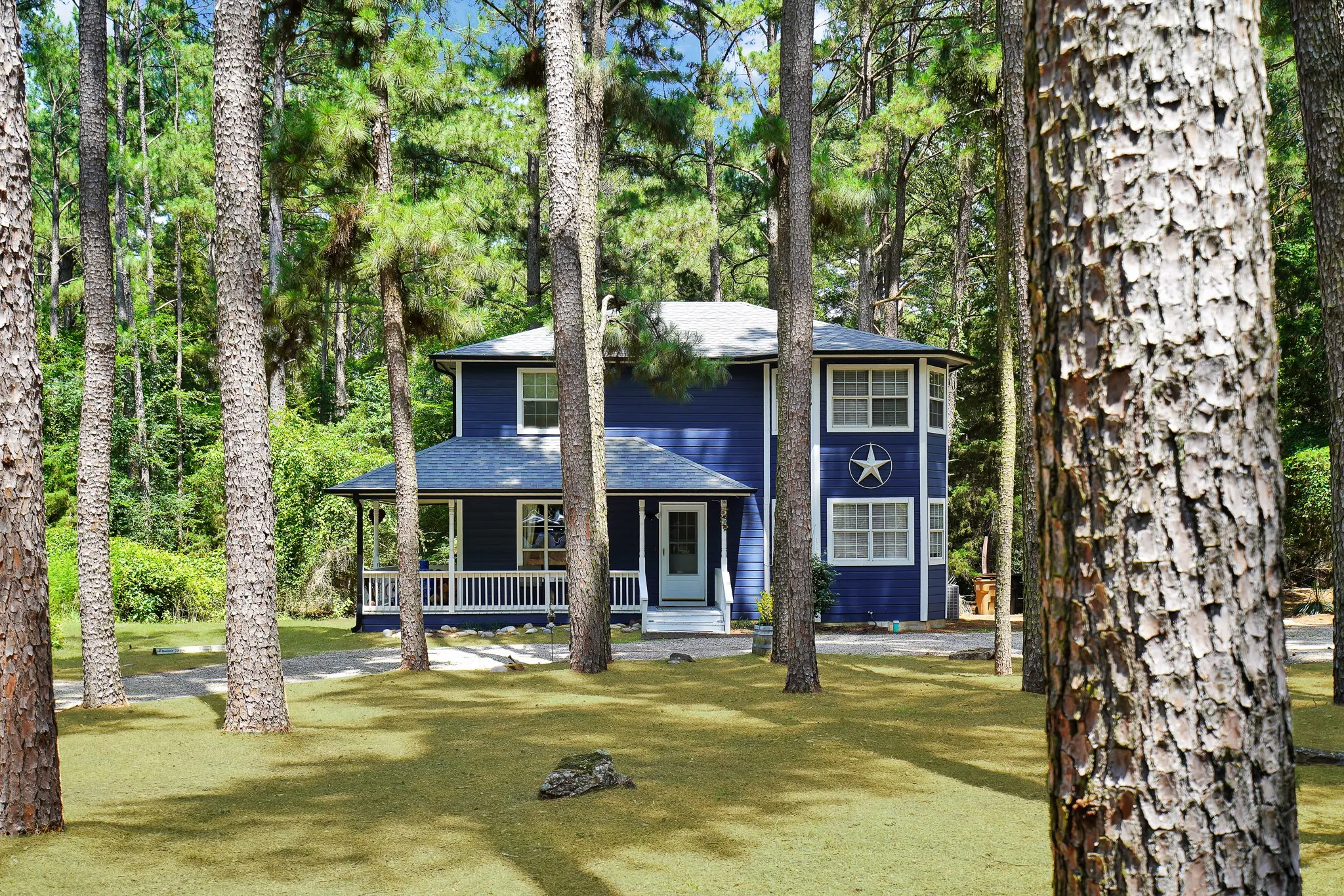View of front of property with a porch, roof with shingles, and a front lawn