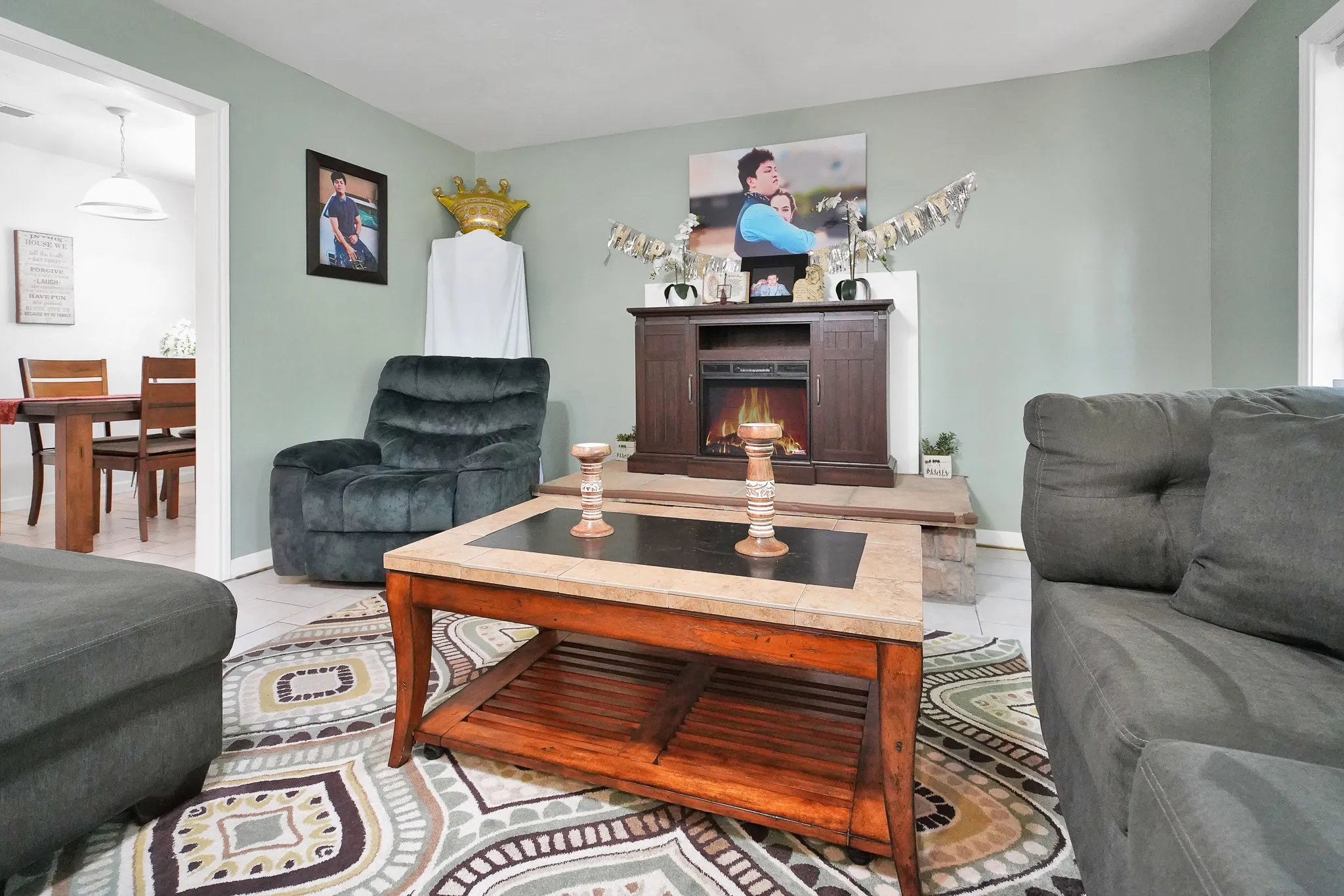 Living area with light tile patterned floors and a lit fireplace