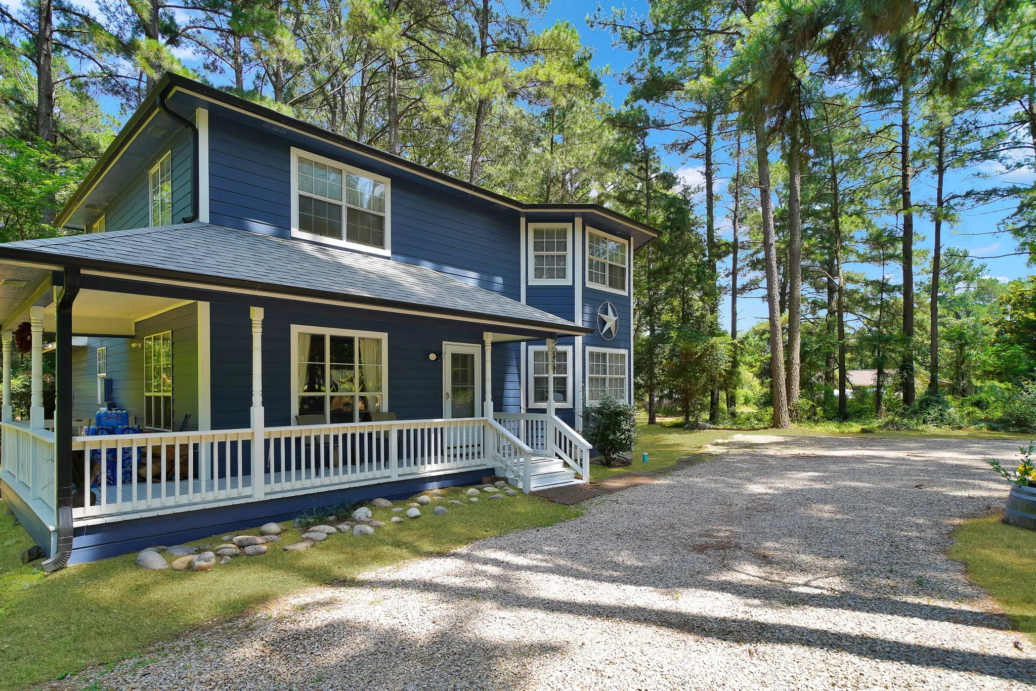 View of front of home with a porch, driveway, and roof with shingles
