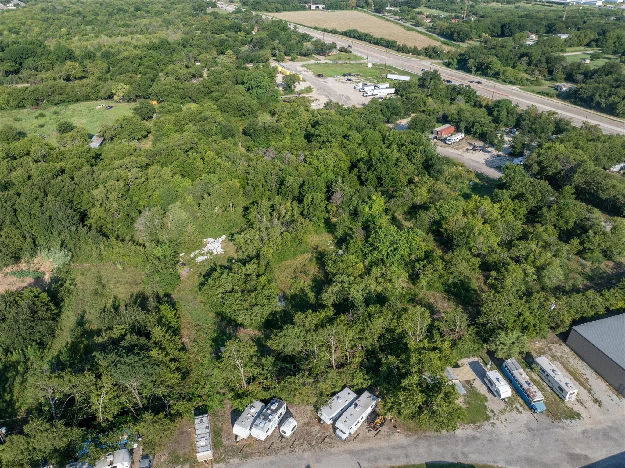 Aerial view of property and surrounding area featuring a forest