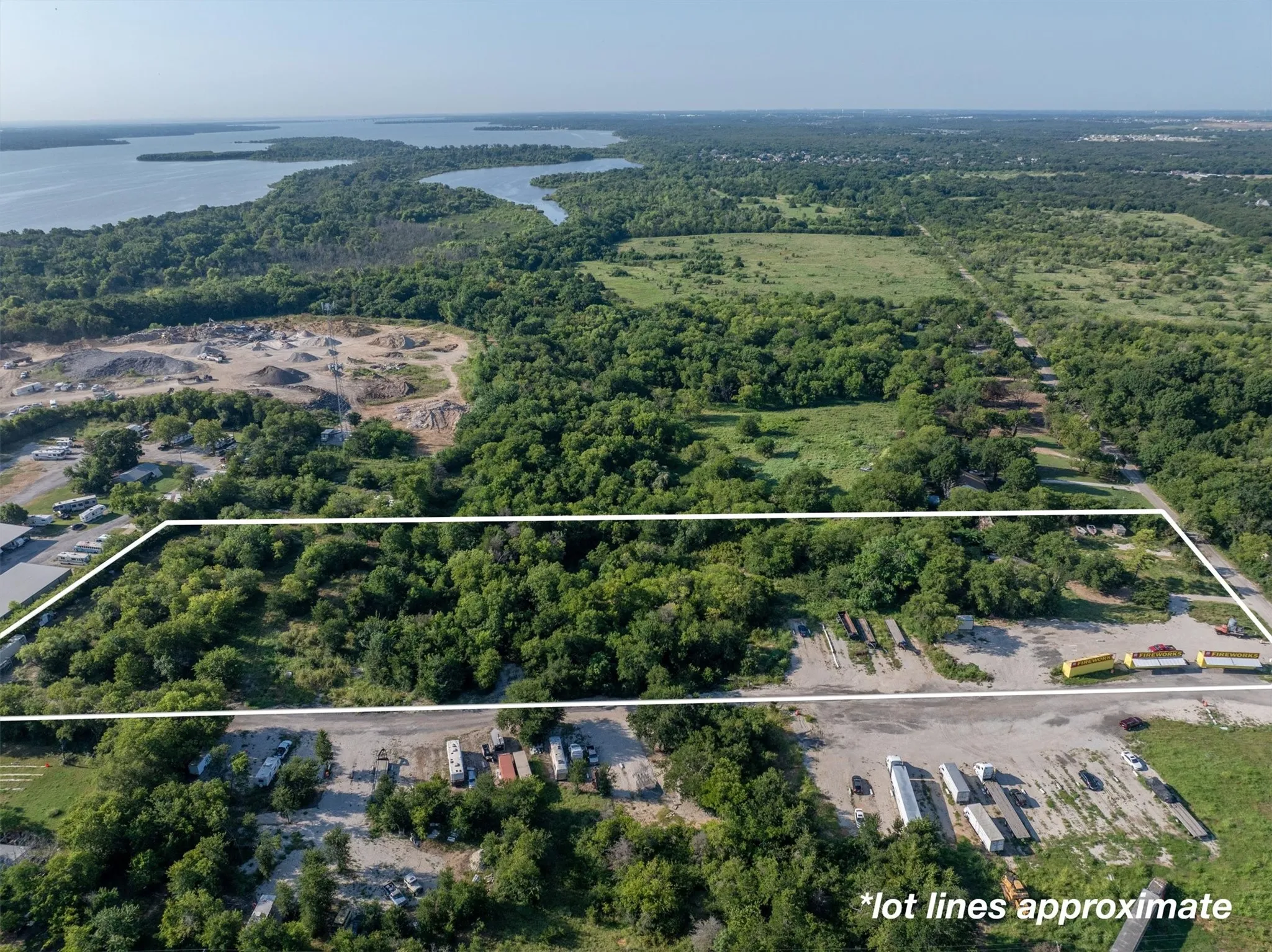 Aerial view of property and surrounding area with a nearby body of water and property boundaries highlighted