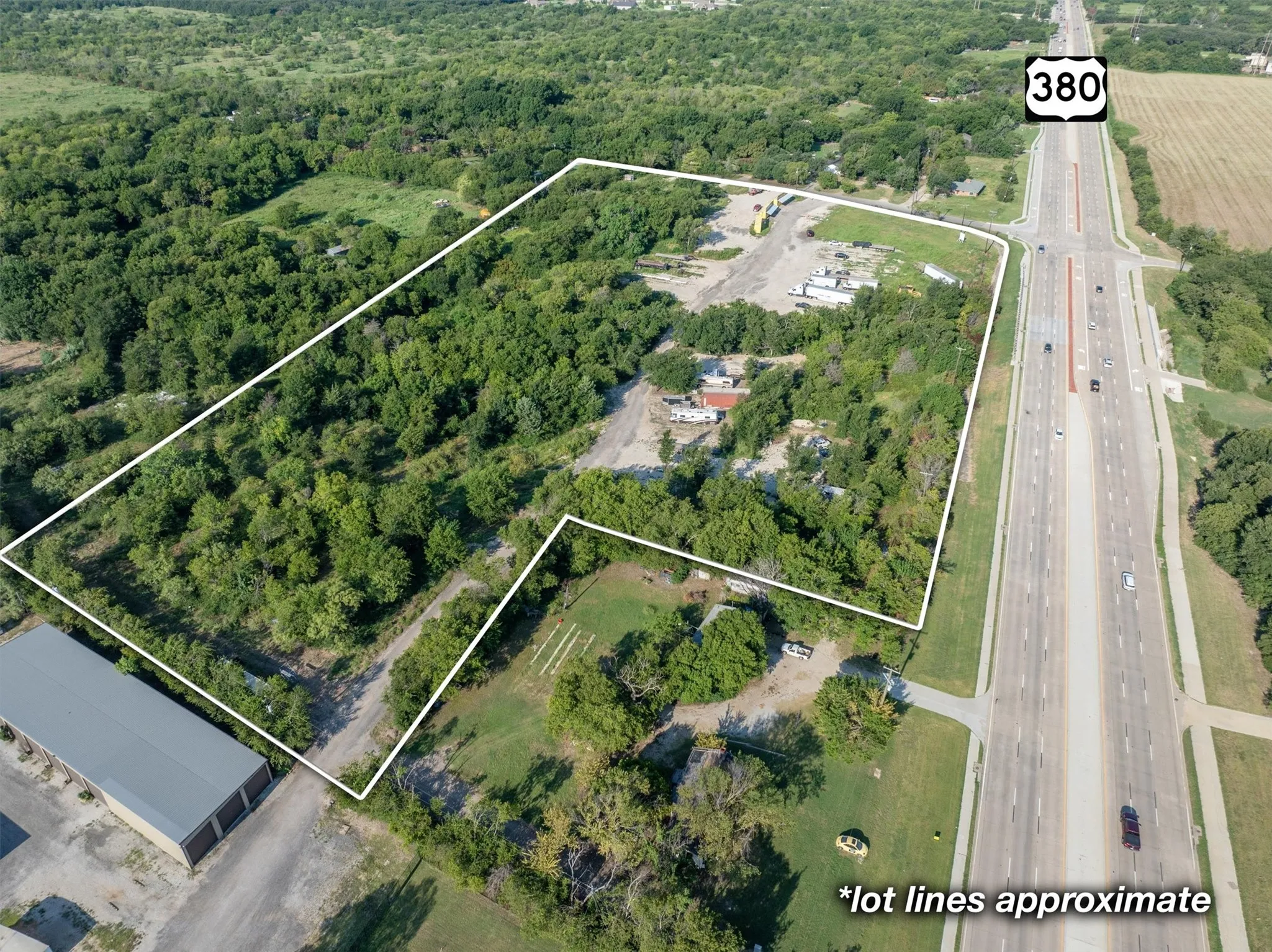 Aerial view of property and surrounding area with property boundaries highlighted and a major roadway