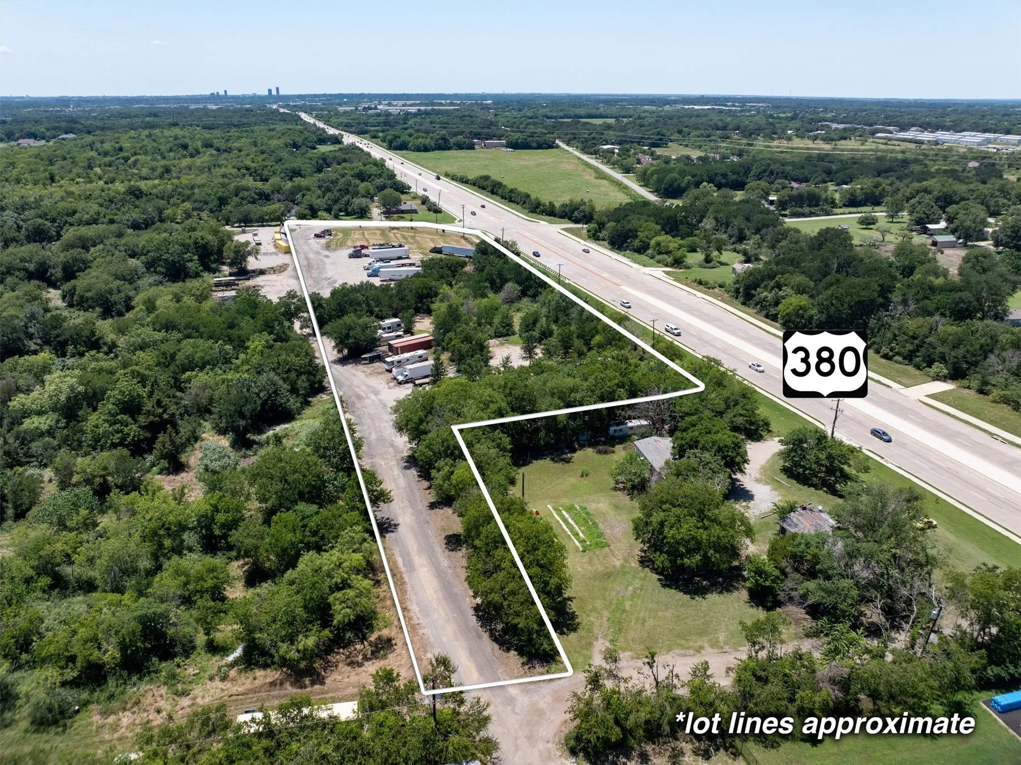 Aerial view of property and surrounding area featuring a highway and property boundaries highlighted
