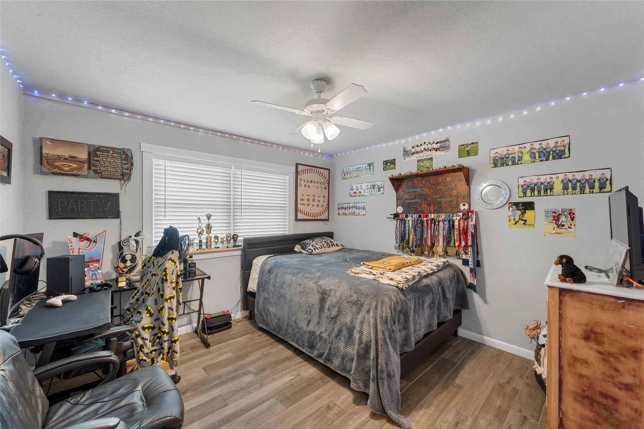 Bedroom featuring wood finished floors, a textured ceiling, and a ceiling fan
