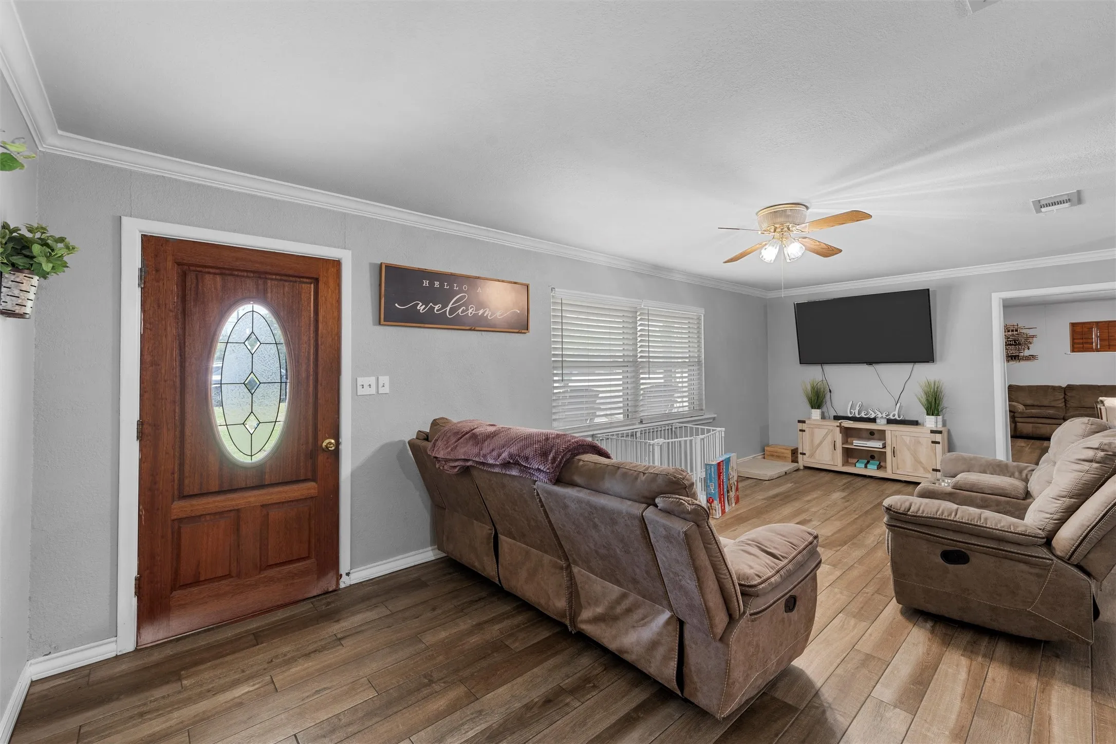 Living area with crown molding, ceiling fan, and hardwood / wood-style flooring