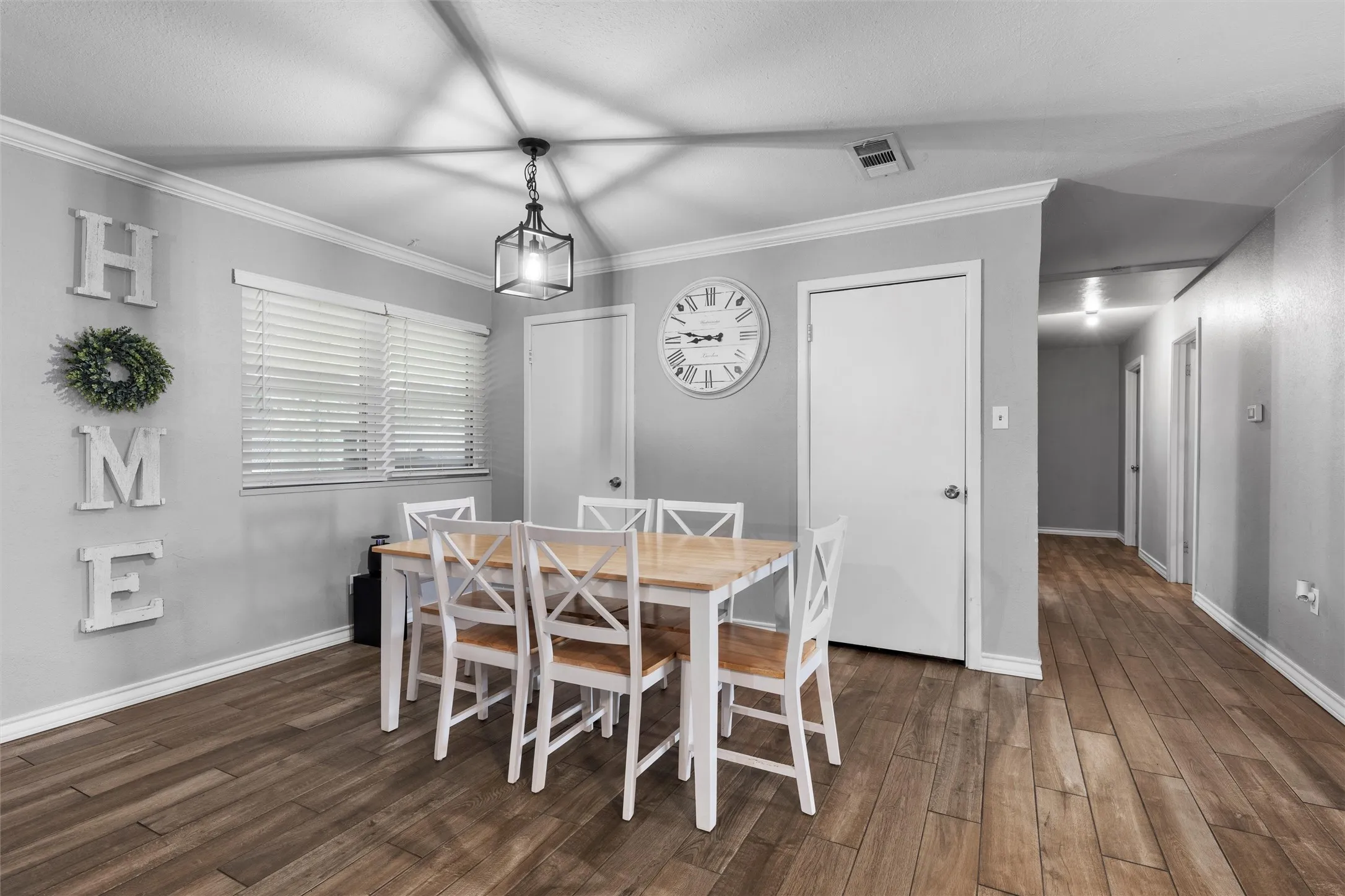 Dining space featuring dark wood-type flooring and crown molding