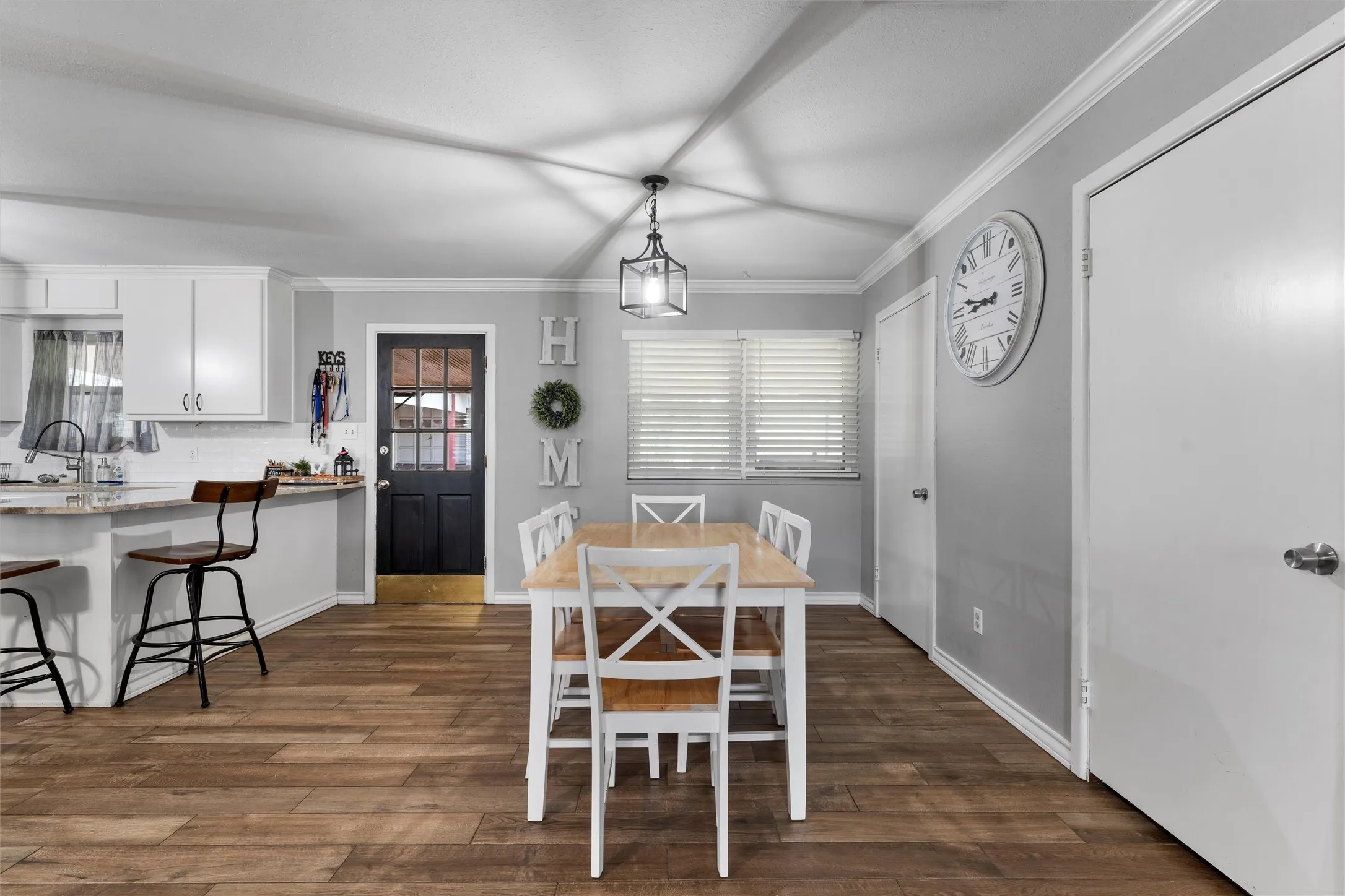 Dining room with dark wood-type flooring and crown molding
