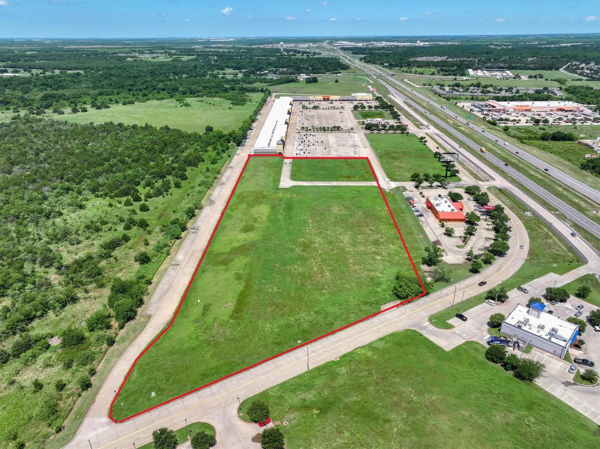 Aerial view of property's location with a major roadway and property parcel outlined