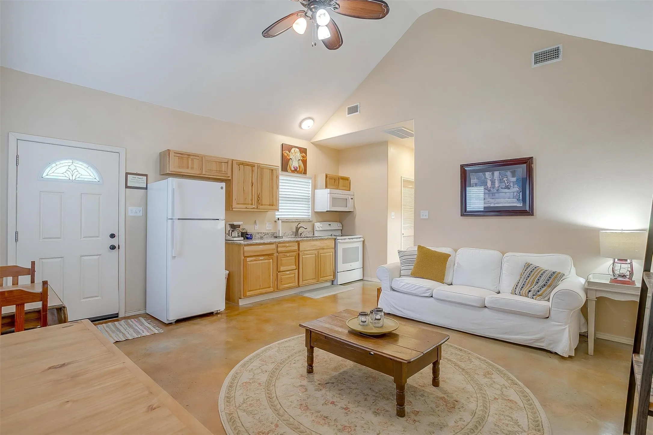 Meadows Cabins A, B, C, D- iving room featuring finished concrete floors, a ceiling fan, and high vaulted ceiling