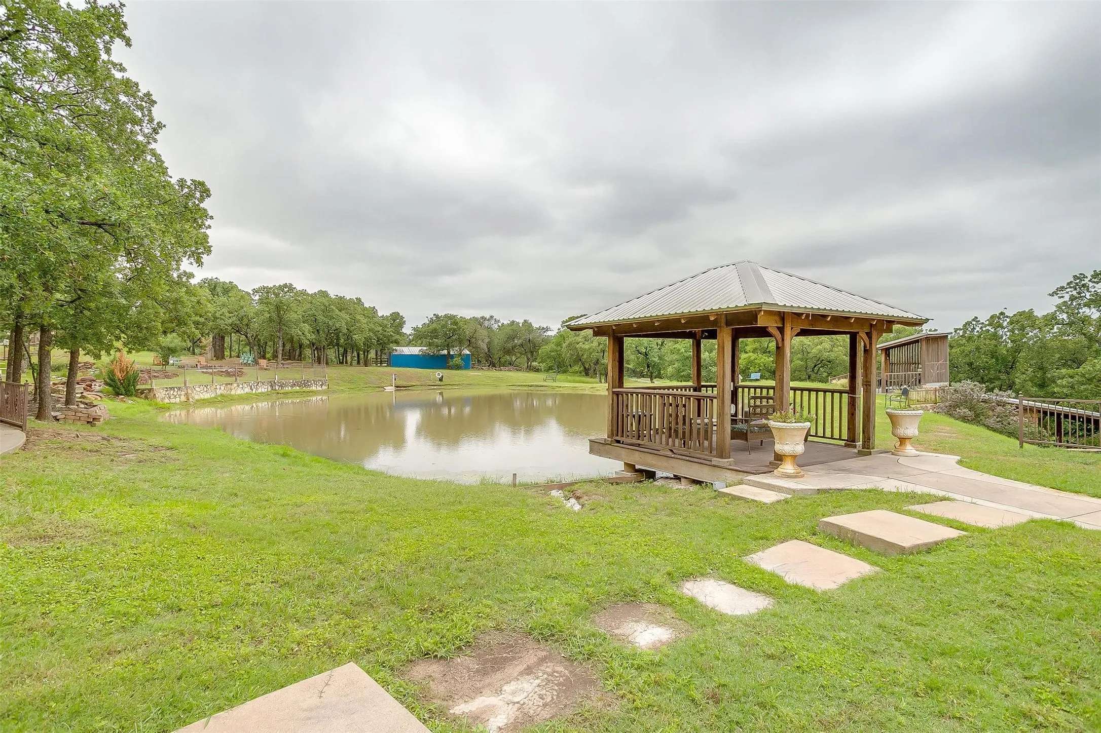 View of grassy yard featuring a gazebo and a water view (pond).