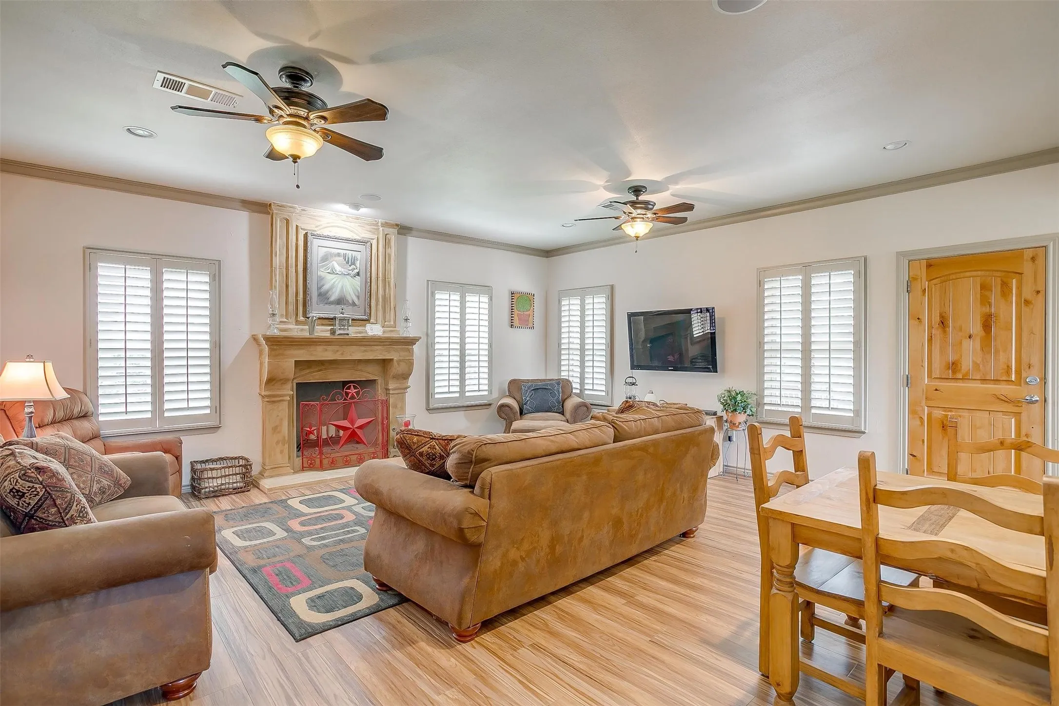 Still Water Cabin- Living area featuring a ceiling fan, healthy amount of natural light, crown molding, and light wood finished floors