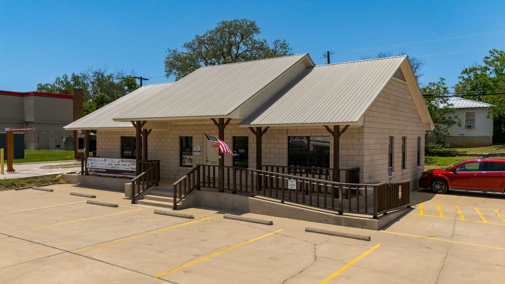 View of front of home with a porch, uncovered parking, and a metal roof