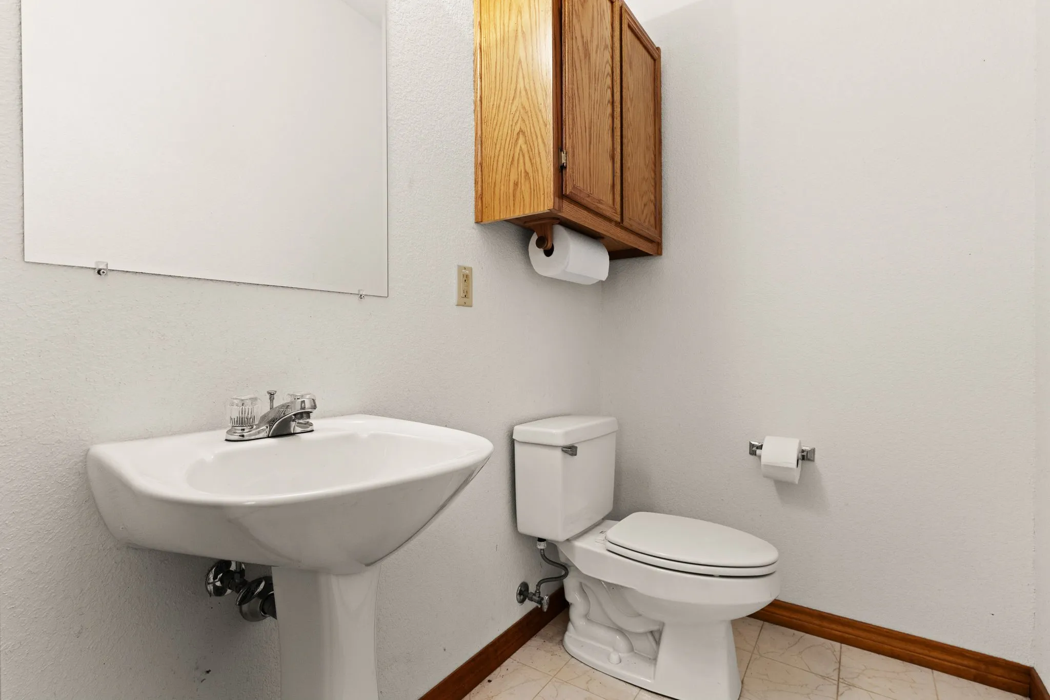 Half bathroom with baseboards and toilet