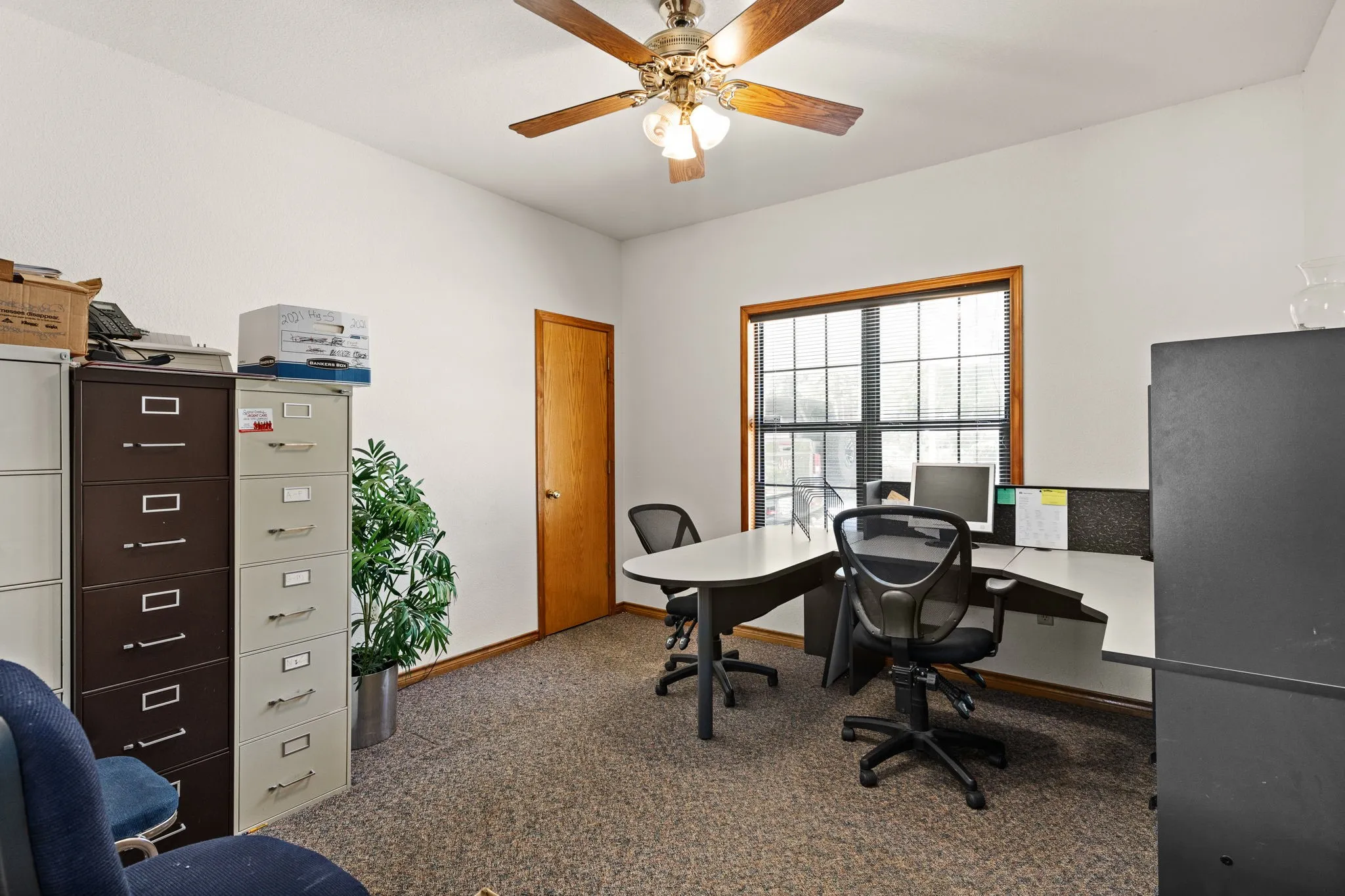 Office area with carpet floors and ceiling fan