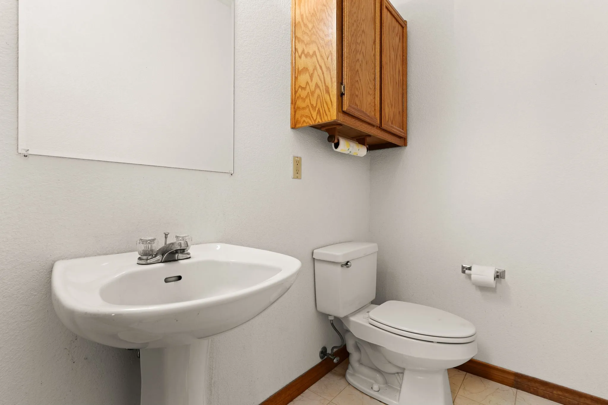 Half bathroom with toilet and baseboards