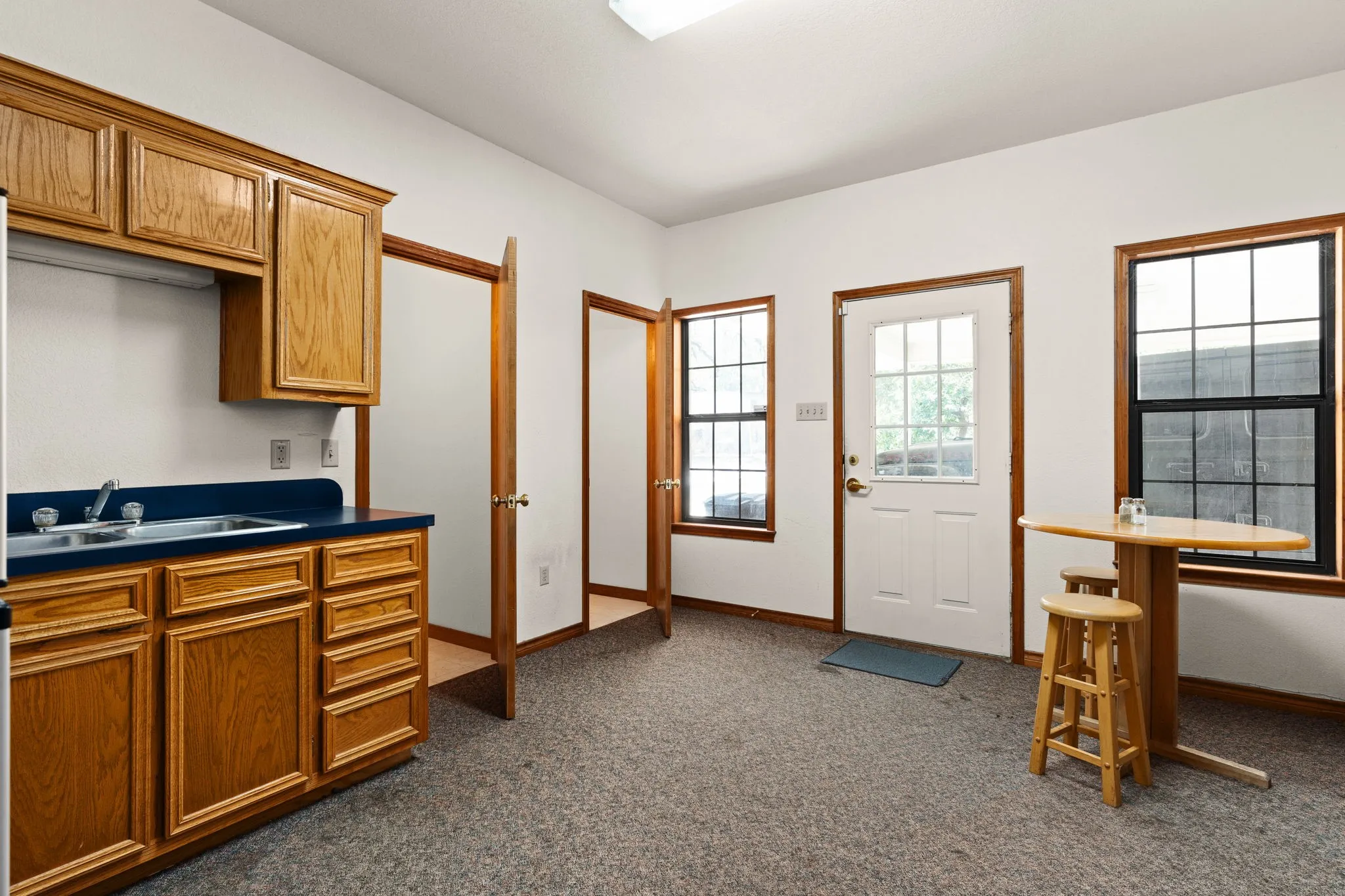 Kitchen featuring dark carpet, brown cabinetry, and dark countertops