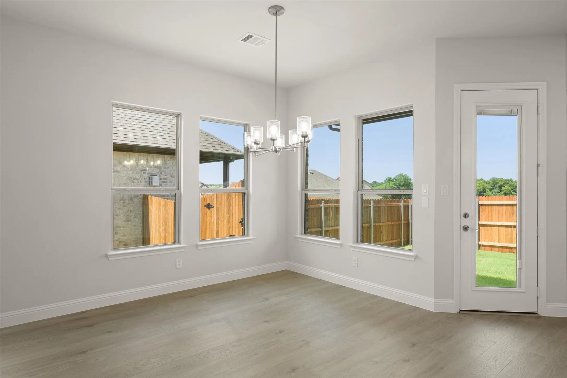 Unfurnished dining area featuring a chandelier and wood finished floors