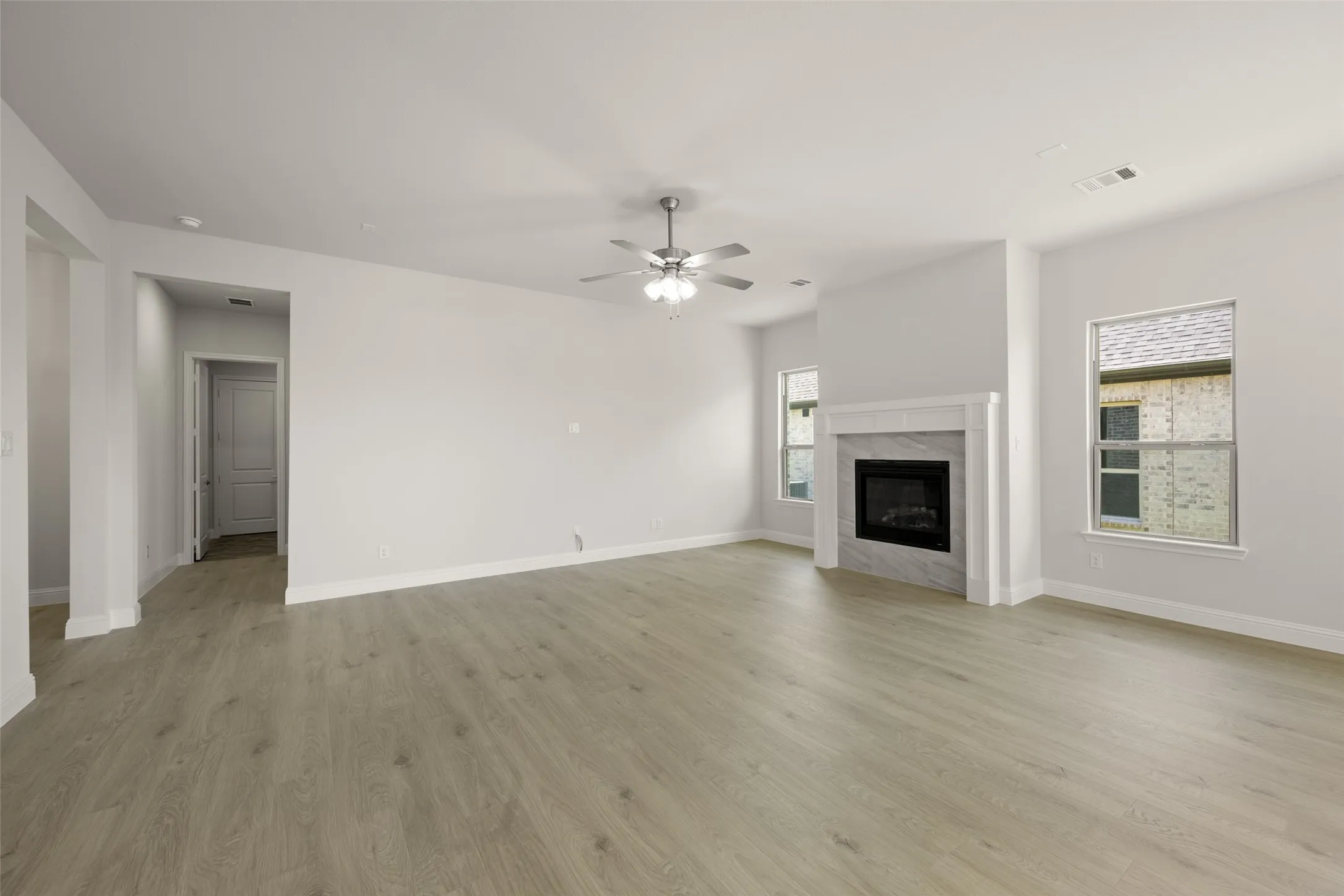 Unfurnished living room featuring ceiling fan, light wood-type flooring, and a premium fireplace