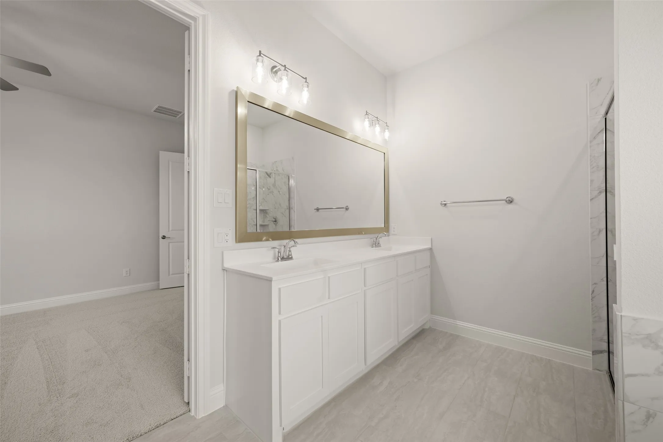 Full bath featuring a ceiling fan, a marble finish shower, and double vanity