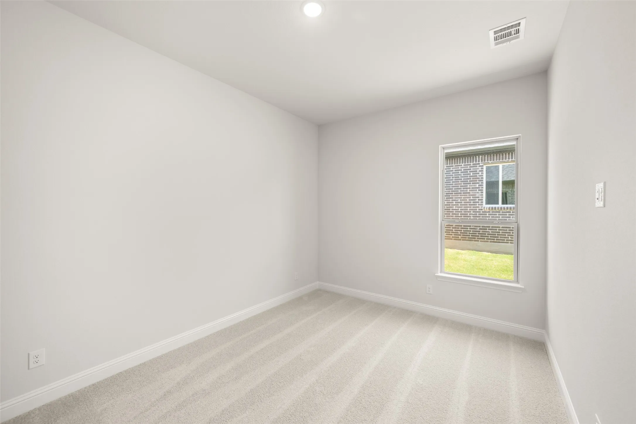 Empty room featuring light colored carpet and recessed lighting