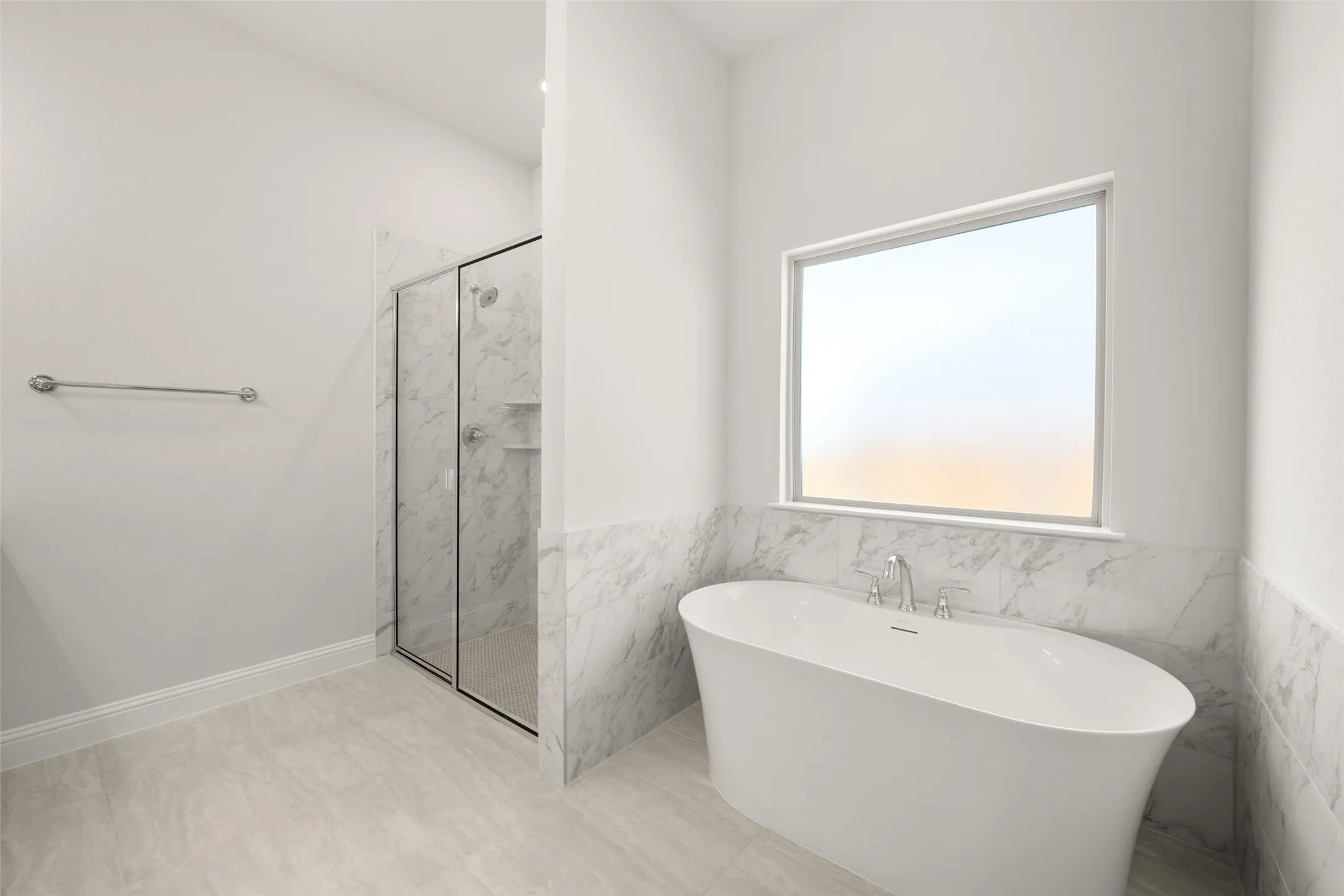 Full bathroom with a freestanding tub, a marble finish shower, tile walls, and wainscoting
