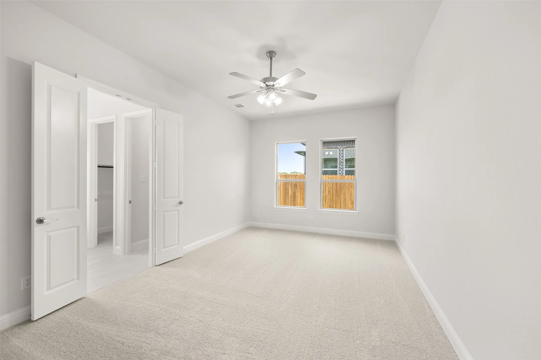 Empty room featuring carpet flooring and ceiling fan